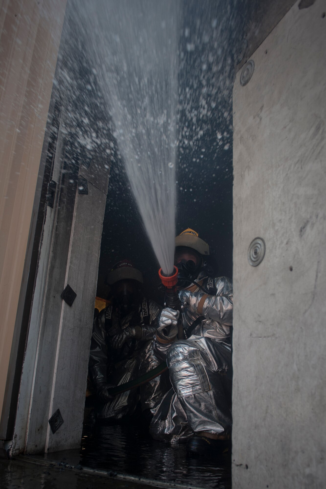 Two members from the 23rd Civil Engineer Squadron fire department help ventilate a room filled with smoke during training at Moody Air Force Base, Ga., June 24, 2011.The firefighters were training for an upcoming deployment. (U.S. Air Force photo by Airman 1st Class Nicholas Benroth/Released)