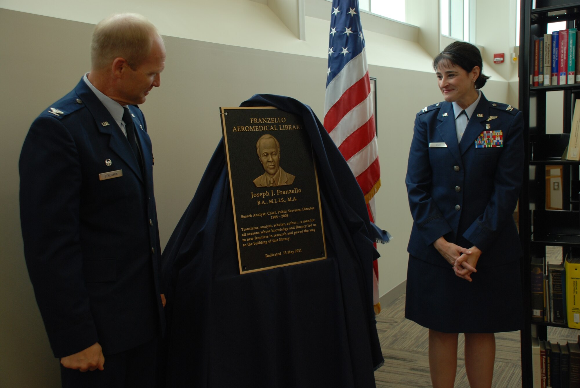 Colonel Christian Benjamin, Commander, United States Air Force School of Aerospace Medicine (USAFSAM), and Colonel Karen Weis, Dean, USAFSAM, unveil a plaque at the dedication of the school’s Franzello AeroMedical Library at Wright-Patterson Air Force Base, Ohio. The library is named in honor of Joseph Franzello, a former director of the library.