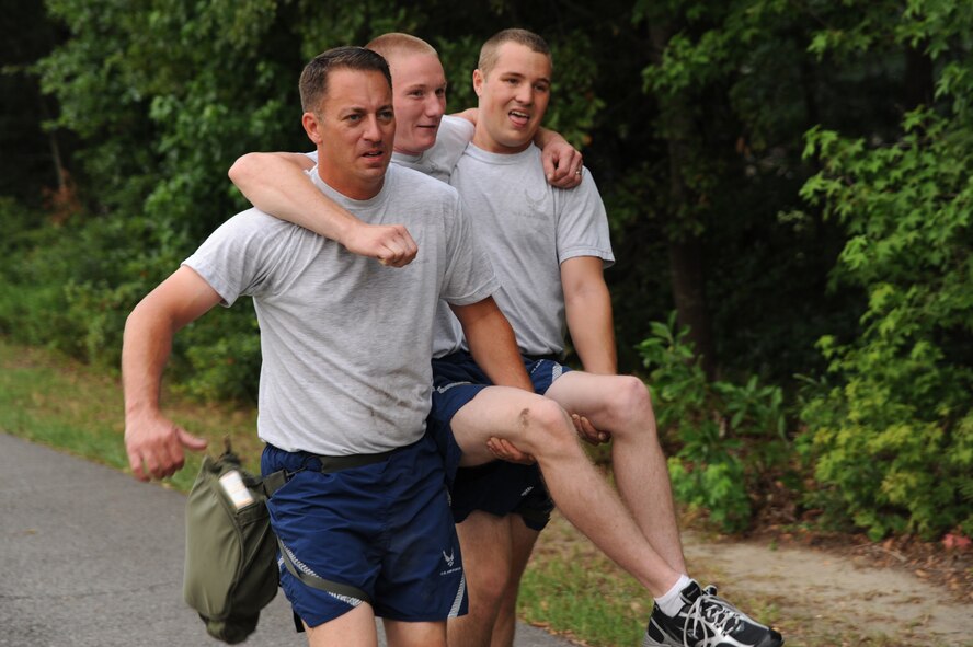 Tech. Sgt. Jonathan Smiddy and Senior Airman Richard Douglas carry Senior Airman Dylan Sanford on June 22, 2011, at Joint Base Charleston, S.C. Members from the 437th Aerial Port Squadron and the 437th Aircraft Maintenance Squadron met every Wednesday to prepare for the 2011 Air Mobility Rodeo held at Joint Base Lewis-McCord, Wash. Sergeant Smiddy, Airman Douglas and Airman Sanford are from the 437th AMXS. (U.S. Air Force Photo/Staff Sgt. Nicole Mickle) 
