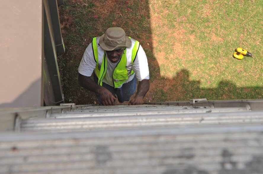 Spencer Howard, a contracted sheet metal mechanic, climbs a ladder to gain access to the roof of the Barksdale Lanes Bowling Center on Barksdale Air Force Base, La., June 27. The contractors were called out to repair leaks in the roof. If left unchecked, the leaks will cause extensive damage to a building. (U.S. Air Force photo/Airman 1st Class Micaiah Anthony)(RELEASED)