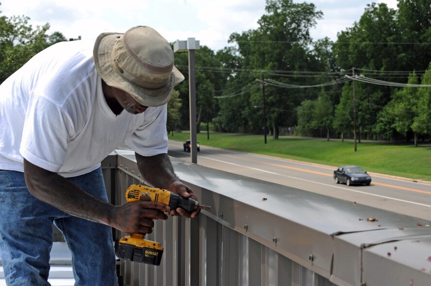 Spencer Howard, a contracted sheet metal mechanic, tightens a screw on the roof of the Barksdale Lanes Bowling Center on Barksdale Air Force Base, La., June 27. The contractors were called out to repair leaks in the roof. If left unchecked, the leaks will cause extensive damage to a building. (U.S. Air Force photo/Airman 1st Class Micaiah Anthony)(RELEASED) 
