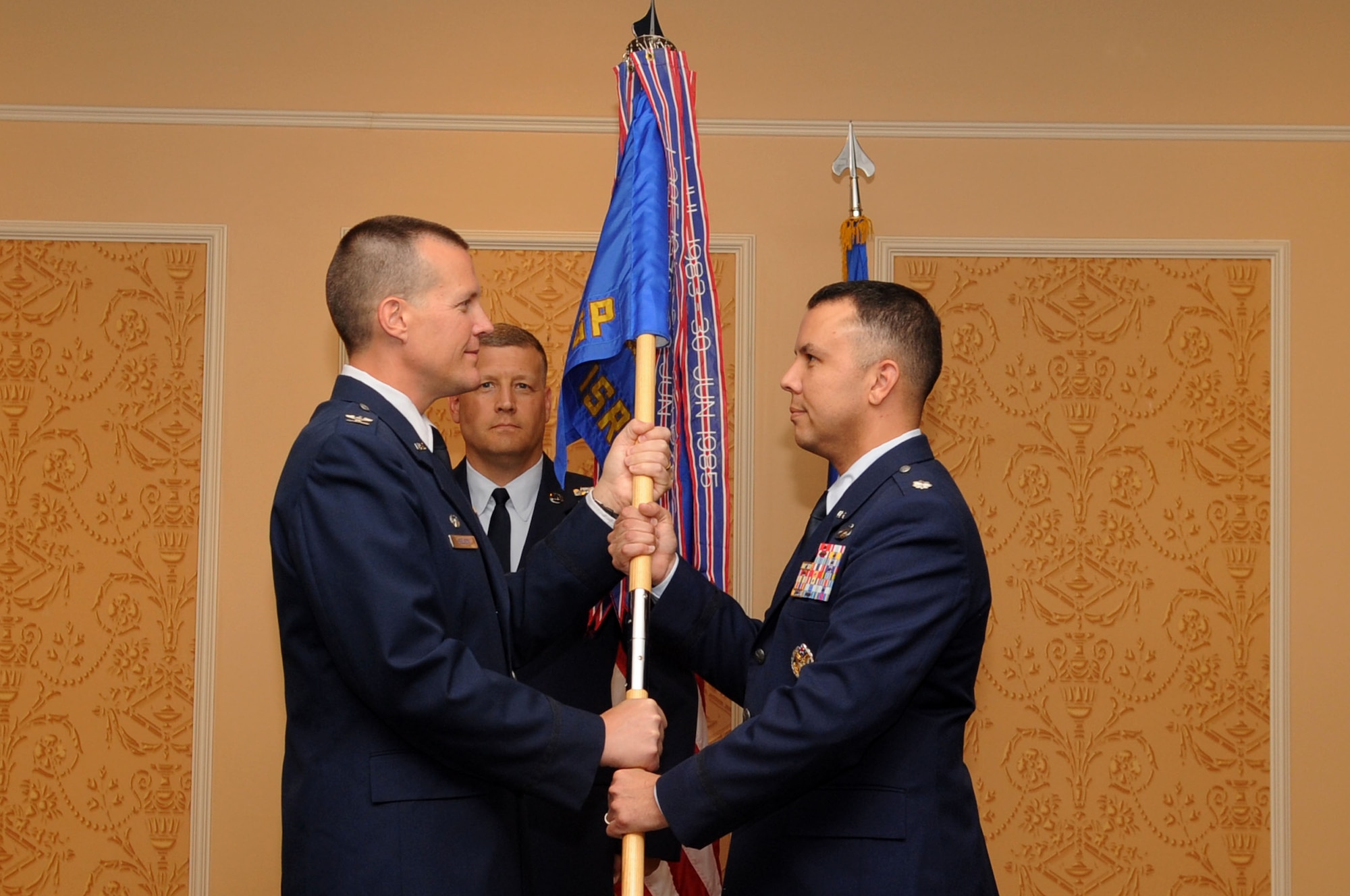 Lt. Col. Patrick M. Shortsleeve (right) accepts the guidon from Col. Paul Nelson, 480th Intelligence, Surveillance and Reconnaissance Wing commander, as he assumes command of the the 497 ISR Group during a change of command ceremony June 24 at the Bayview Commonwealth Center. Colonel Shortsleeve will command more than 800 personnel across four squadrons in a Total Force Integration environment, including two active-duty squadrons, one Air National Guard and one Reserve squadron. (U.S. Air Force photo by Airman 1st Class Rachael Watson/Released)