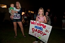 Danika, daughter of Senior Airman David Watson, 823rd Base Defense Squadron, shows off a welcome home sign in anticipation for her father’s return June 26, 2011, at Moody Air Force Base, Ga. Friends and family gathered around 2 a.m. to welcome their loved ones after a six-month deployment to Afghanistan. (U.S. Air Force photo by Staff Sgt. Jamal D. Sutter/Released)