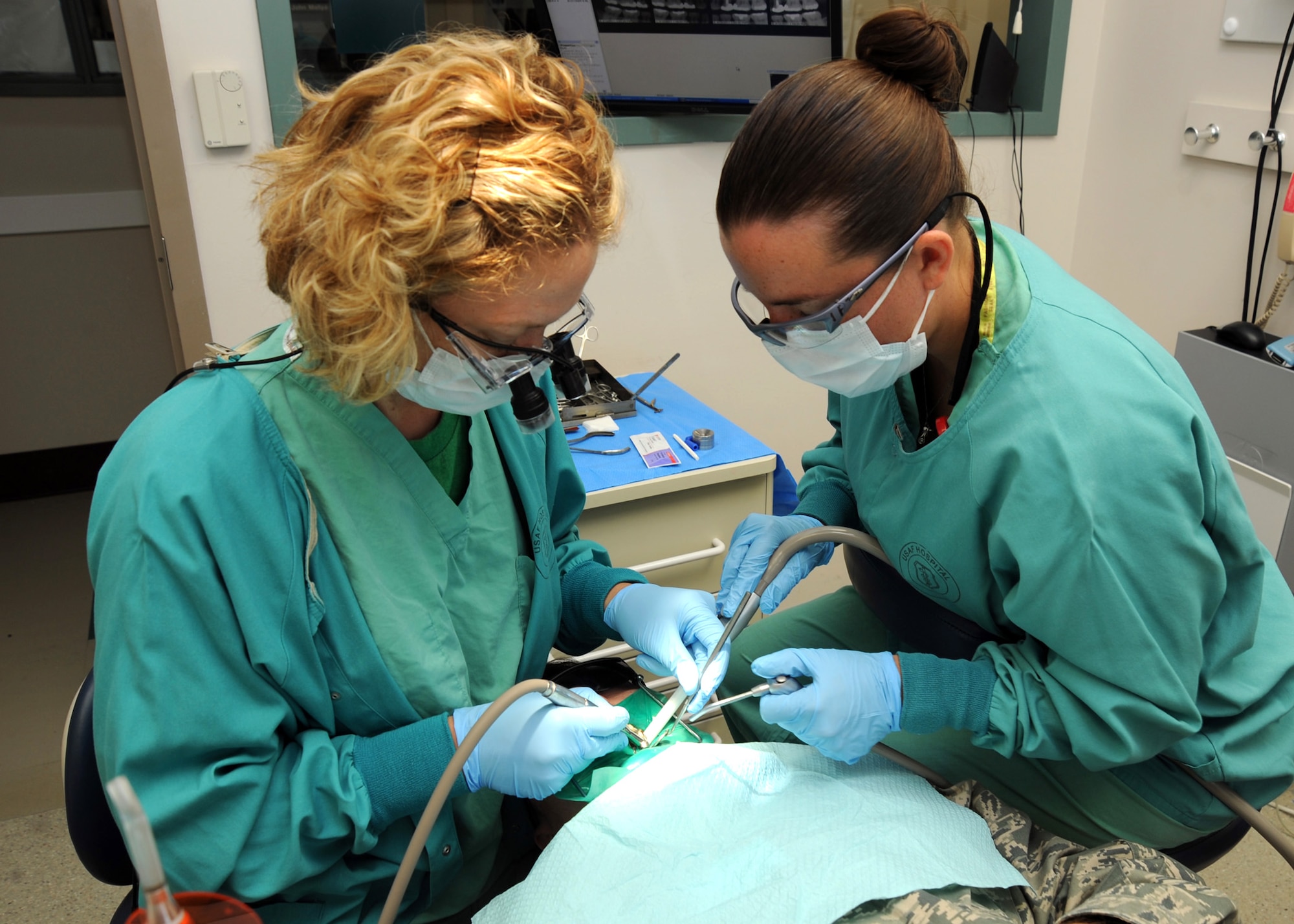 Capt. (Dr.) Kelly Ramey, 22nd Medical Group dentist, performs a dental procedure on Master Sgt. Curtis Davis, 22nd Maintenance Squadron metals NCOIC, with Airman 1st Class Tara Freed, 22 MDG dental assistant, at the dental clinic June 20, 2011, McConnell Air Force Base, Kan.  Dental personnel stress prevention is the key to avoid dental problems.  (U.S. Air Force photo/Staff Sgt. Dallas Edwards)