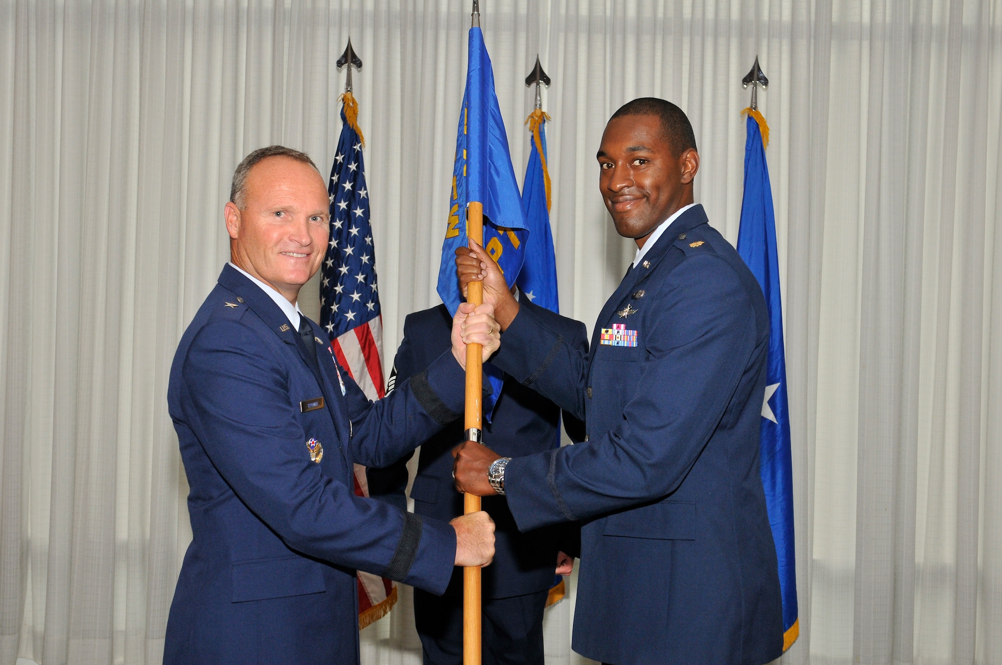 Brigadier Gen. James S. Browne, 325th Fighter Wing commander, passes command of the 325th Comptroller Squadron to Maj. Christopher Carroll during a change of command ceremony June 24. Major Carroll replaces Maj. Ericka Farmer-Hill who departs Tyndall to attend U.S. Naval War Collge in Newport, R.I. Major Carroll arrives from Scott Air Force Base, Ill., where he served as the executive officer at Headquarters, Air Mobility Command, Financial Management. (U.S. Air Force photo by Lisa Norman) 