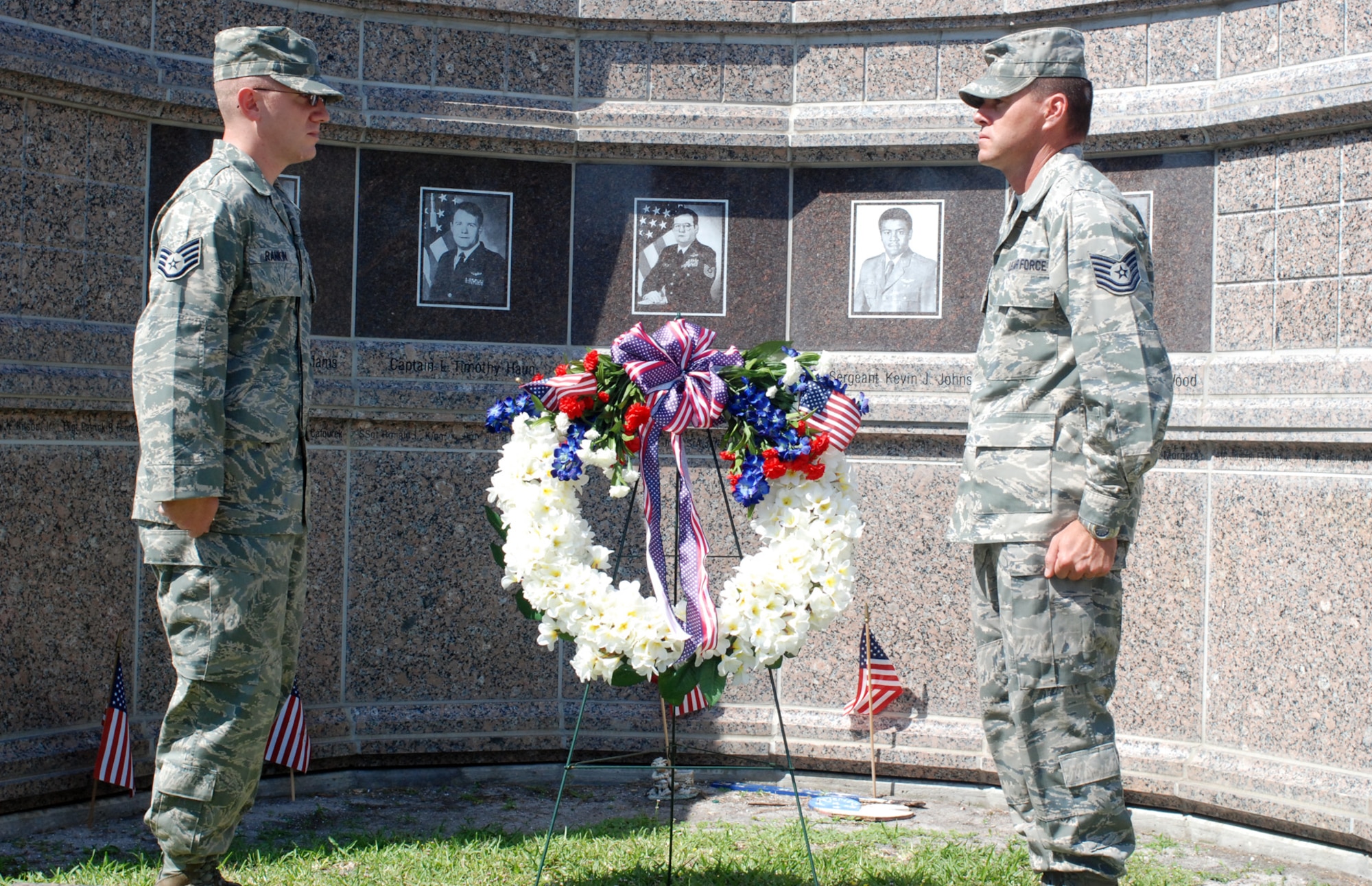 PATRICK AIR FORCE BASE, Fla.- Staff Sgt. Jason Rankin and Tech. Sgt David Drury stand at attention after laying  the wreath in front of the Khobar Towers memorial here. The laying of the wreath is a way to remember the 19 U.S servicemembers that lost their lives 15 years ago after a fuel truck exploded in front of the Khobar Towers. Many 920th Rescue Wing Airmen were in attendance to share the memories of their fallen comrades. (U.S. photo/Airman First Class Natasha Dowridge)