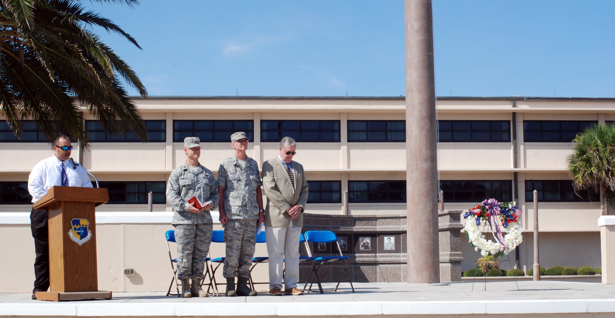 PATRICK AIR FORCE BASE, Fla.- Darrell Hankins, former 1st Rescue Group airman and current 920th Rescue Wing Resource Advisor here greets those attending the memorial for the Khobar Towers. Col. George Raeder, 920th RQW Maintenance Mission Group commander, Capt. Matthew Simpson, 920th RQW Chaplain and retired Col. Thomas Friers, former 1st Rescue Group Commander join Mr. Hankins on stage to add special touches to the ceremony. The Wing has a 50-year history of saving lives, and the Airmen here have rescued nearly 1,500 personnel in peacetime and in combat. They live by the motto, "these things we do, that others may live." (U.S. photo/Airman First Class Natasha Dowridge)