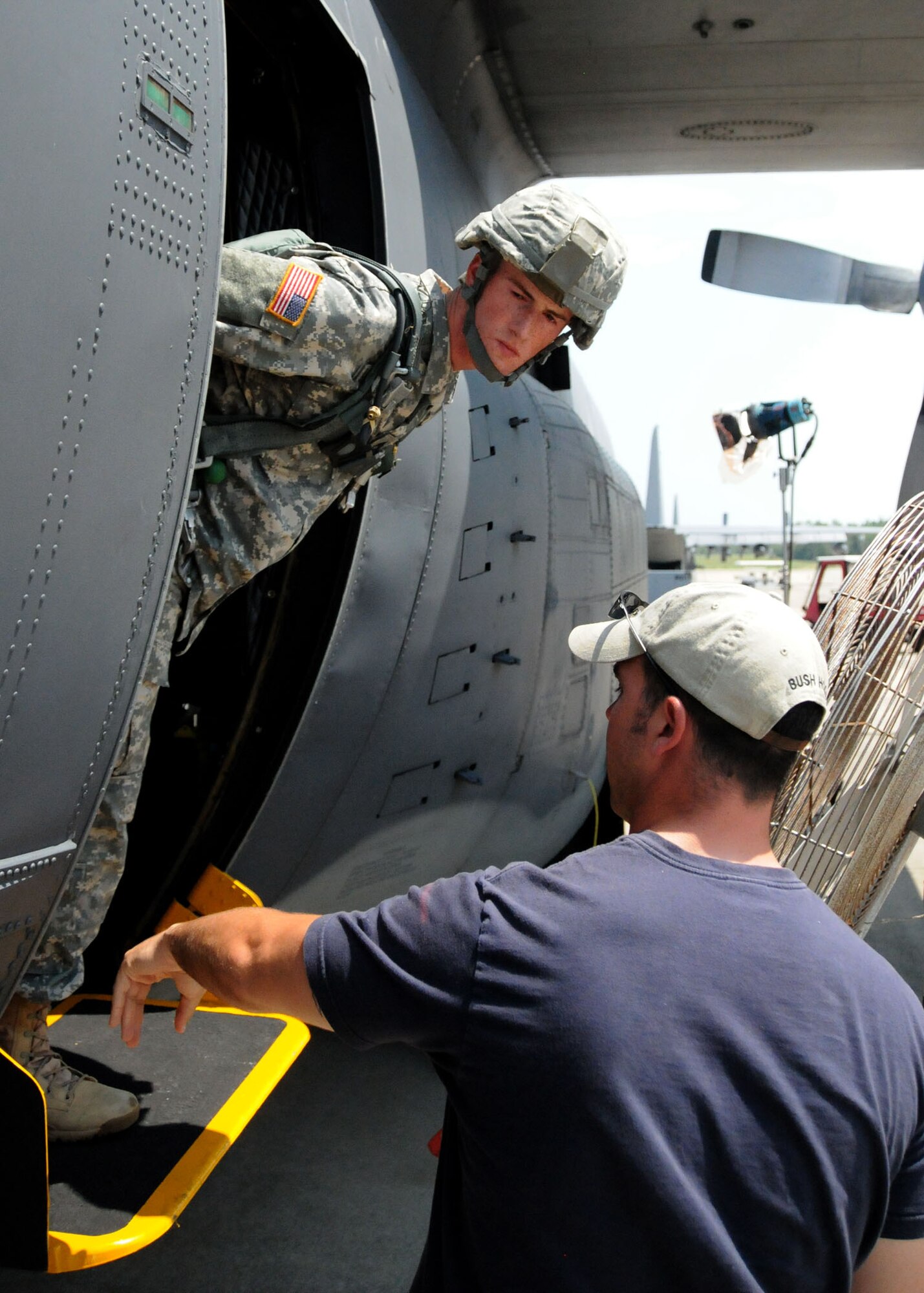 Army Pvt. William Lourash, a student awaiting training at the U.S. Army Airborne School, receives instruction from Staff Sgt. Nick Niday, an Airborne school course manager, during a simulated jump on the flight line at Duke Field, Fla., June 14. The production company, WILL Interactive, started work on a choose-your-own-adventure film for Department of Defense jumpmaster training at Fort Benning, Ga., with help from members from the U.S. Army Airborne School. However, when the crew needed a C-130 in portions of the video, the 919th Special Operations Wing offered to support the project at Duke Field June 13-15. (U.S. Air Force photo/Tech. Sgt. Cheryl Foster)