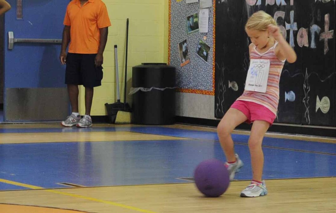 Natalie Galliart, 8, winds up for a home run during a kickball game at the Youth Services Olympics celebration day here June 22.  Terri Dendy, a former olympian, was the guest of honor. (U.S. Air Force photo by Senior Airman Torey Griffith)