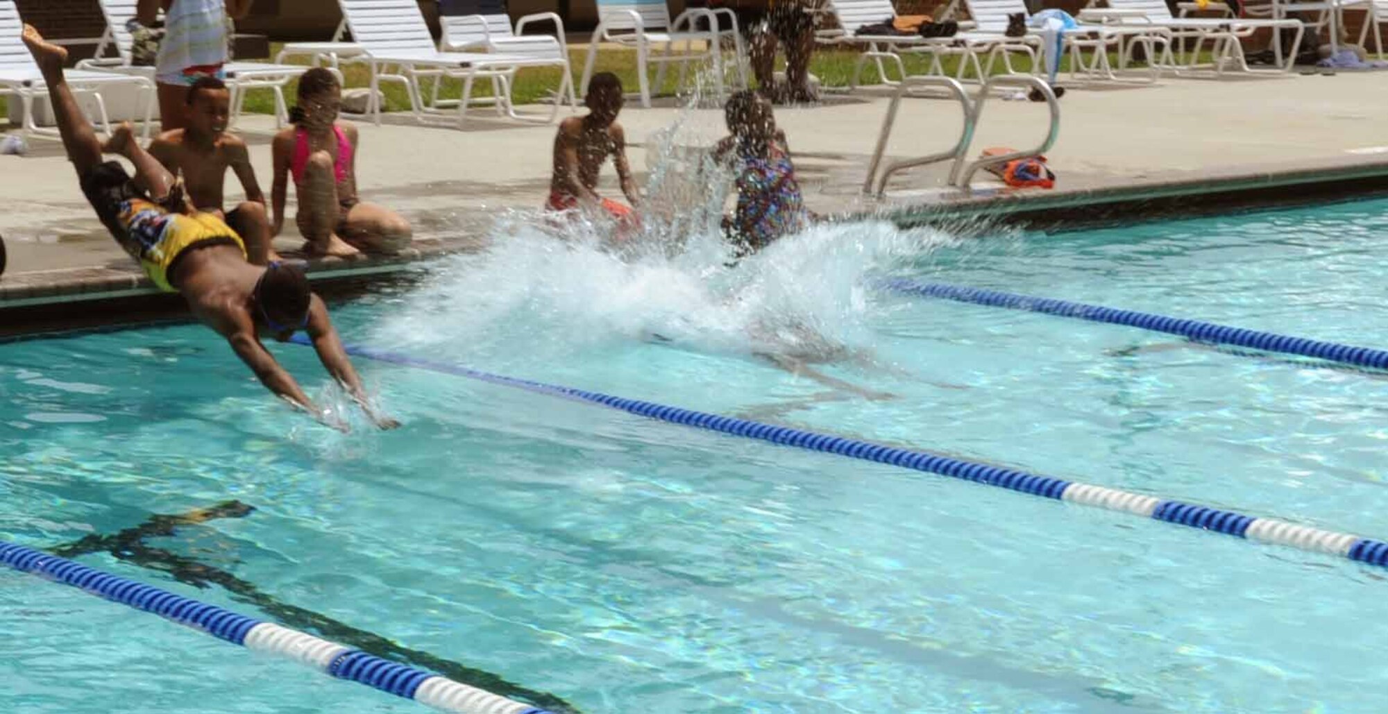 Two contestants dive into the pool as they race in the Youth Services Olympic day celebration here June 22.  Terri Dendy, a former olympian, was the guest of honor. (U.S. Air Force photo by Senior Airman Torey Griffith)