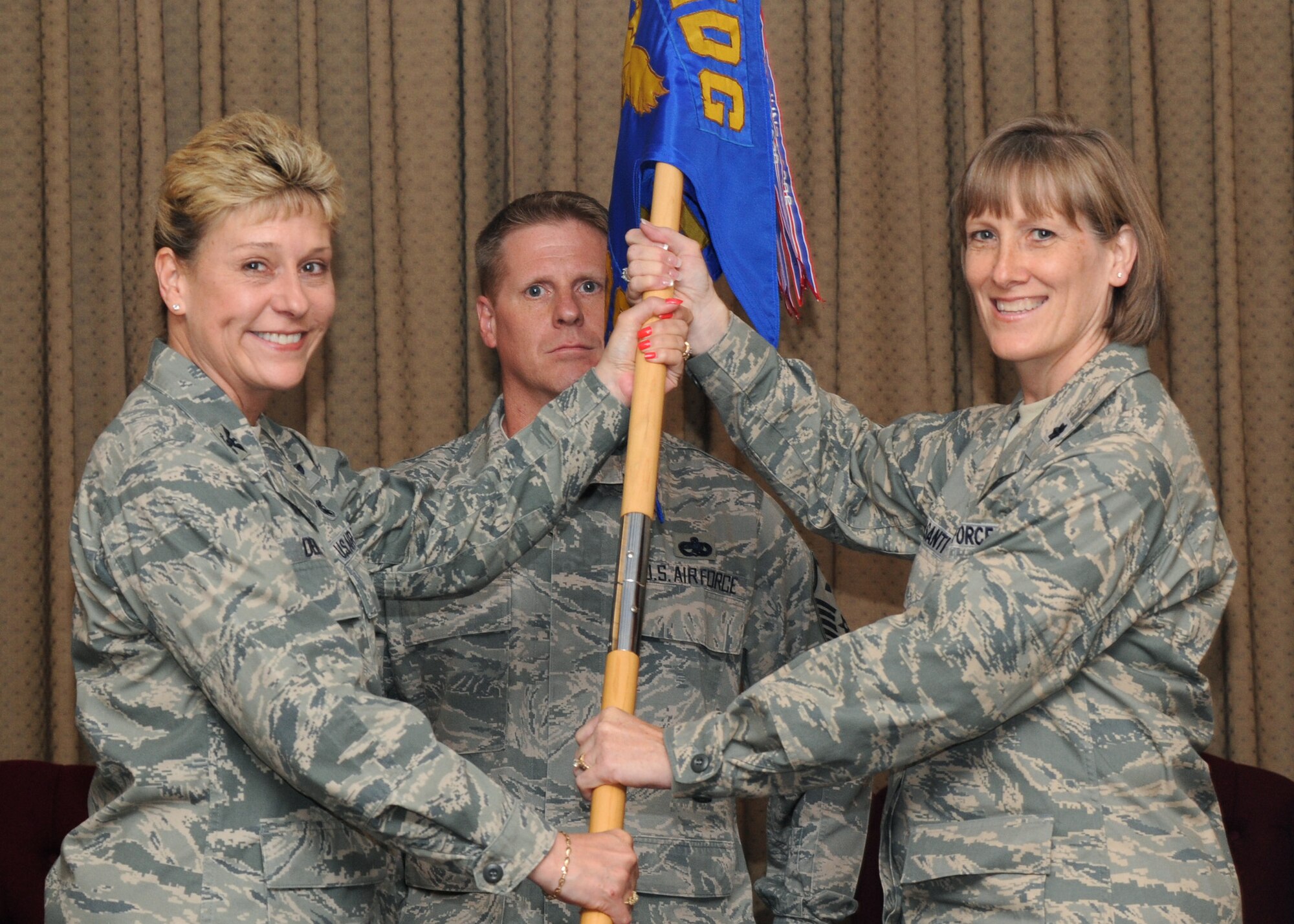 Lt. Col. Marie P. Colasanti recieves the 319th Medical Operations Squadron guidon from Col. Jane Denton, 319th Medical Group commander, during an assumption-of-command ceremony June 24 at Grand Forks Air Force Base. (U.S. Air Force photo/Senior Airman Amber Bennett)