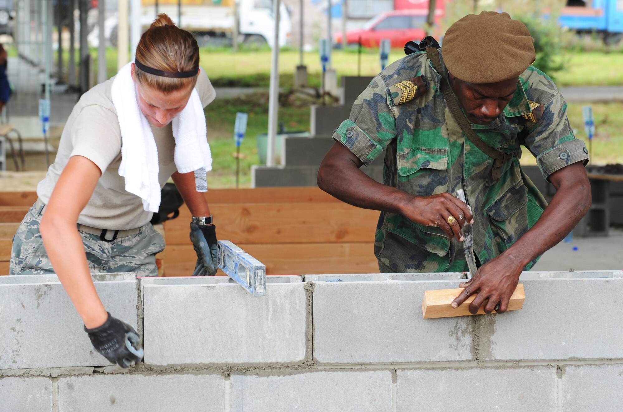 Airman Jennifer Flammang, 820th Rapid Engineer Deployable Heavy Operational Repair Squadron Engineers (RED HORSE), Nellis Air Force Base, Nev., works side-by-side with a soldier form the Suriname army here June 10, in a joint exercise that involves the construction of two schools as part of New Horizons 2011. New Horizons is a cooperative effort between the Government of Suriname and United States Southern Command that provides training opportunities for the U.S. military and Suriname while helping improve the quality of life for the people of Suriname. (Photo by Sgt. Laura Fuerst)