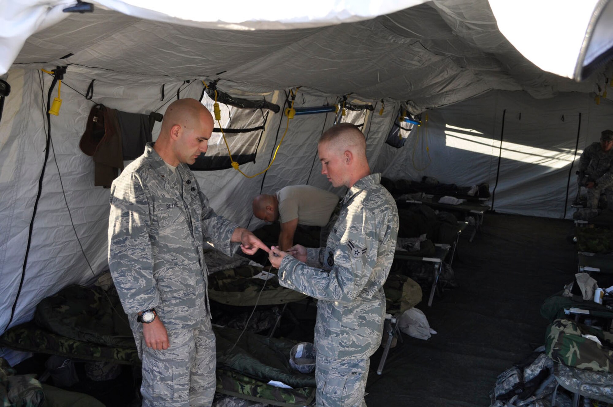2nd Lt. Masten Bethel shows Airman 1st Class Richard Sharber some tricks for tying knots with 550 cord.