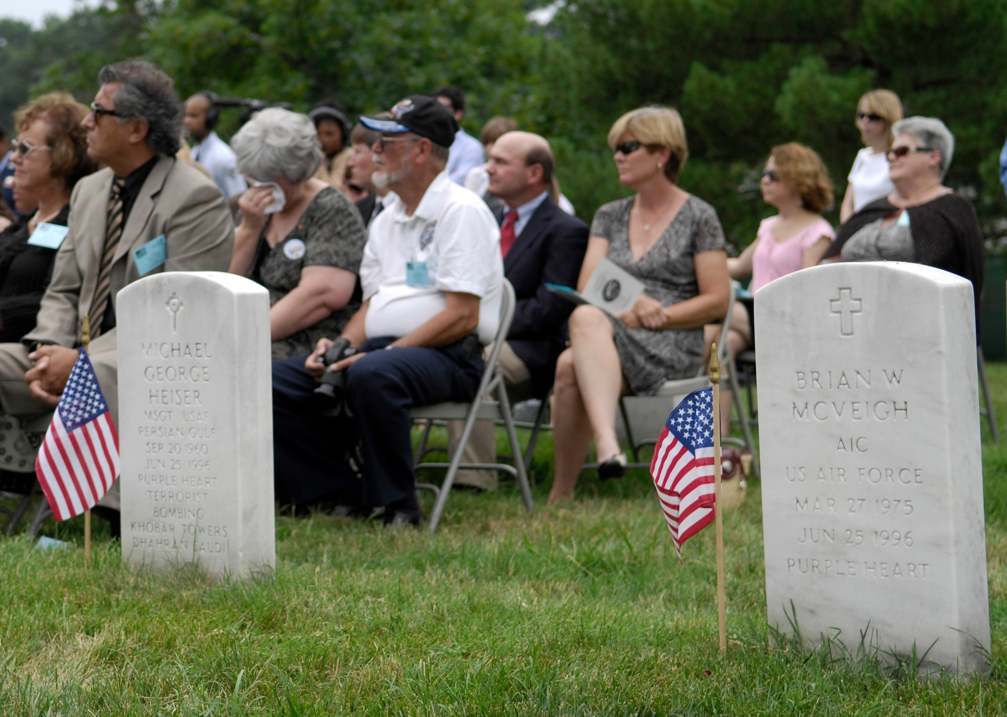 Guests listen during a remembrance ceremony, June 25, 2011, at Arlington National Cemetery, Va., to mark the 15th anniversary since the Khobar Towers bombing. In the foreground lie the headstones of Master Sgt. Michael George Heiser and Airman 1st Class Brian McVeigh, two of the nineteen Airmen killed in the terrorist bombing, June 25, 1996, at Dhahran Air Base, Saudi Arabia. (U.S. Air Force photo/Staff Sgt. Tiffany Trojca) 