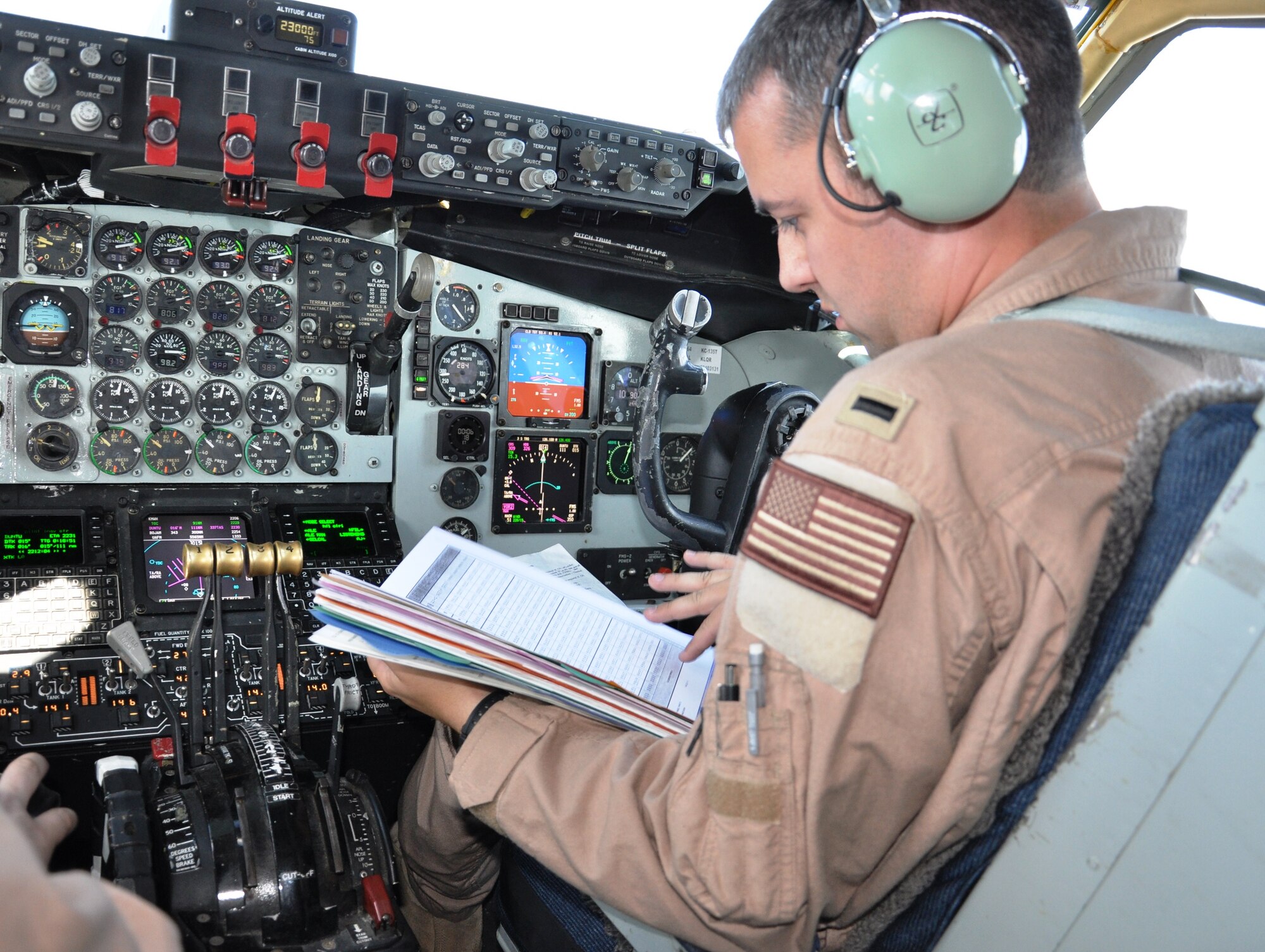 First Lt. Remington Barnes, a 92nd Air Refueling Squadron pilot from Fairchild Air Force Base, Wash., studies a checklist during a historic KC-135 Stratotanker mission over the Arctic Circle on June 21, 2011.  Lieutenant Barnes helped fly the aircraft and three other members to their deployed location at the Transit Center at Manas, Kyrgyzstan.  The Arctic mission provides a new non-stop route from the United States to Kyrgyzstan. (U.S. Air Force Photo/Capt. Kathleen Ferrero)