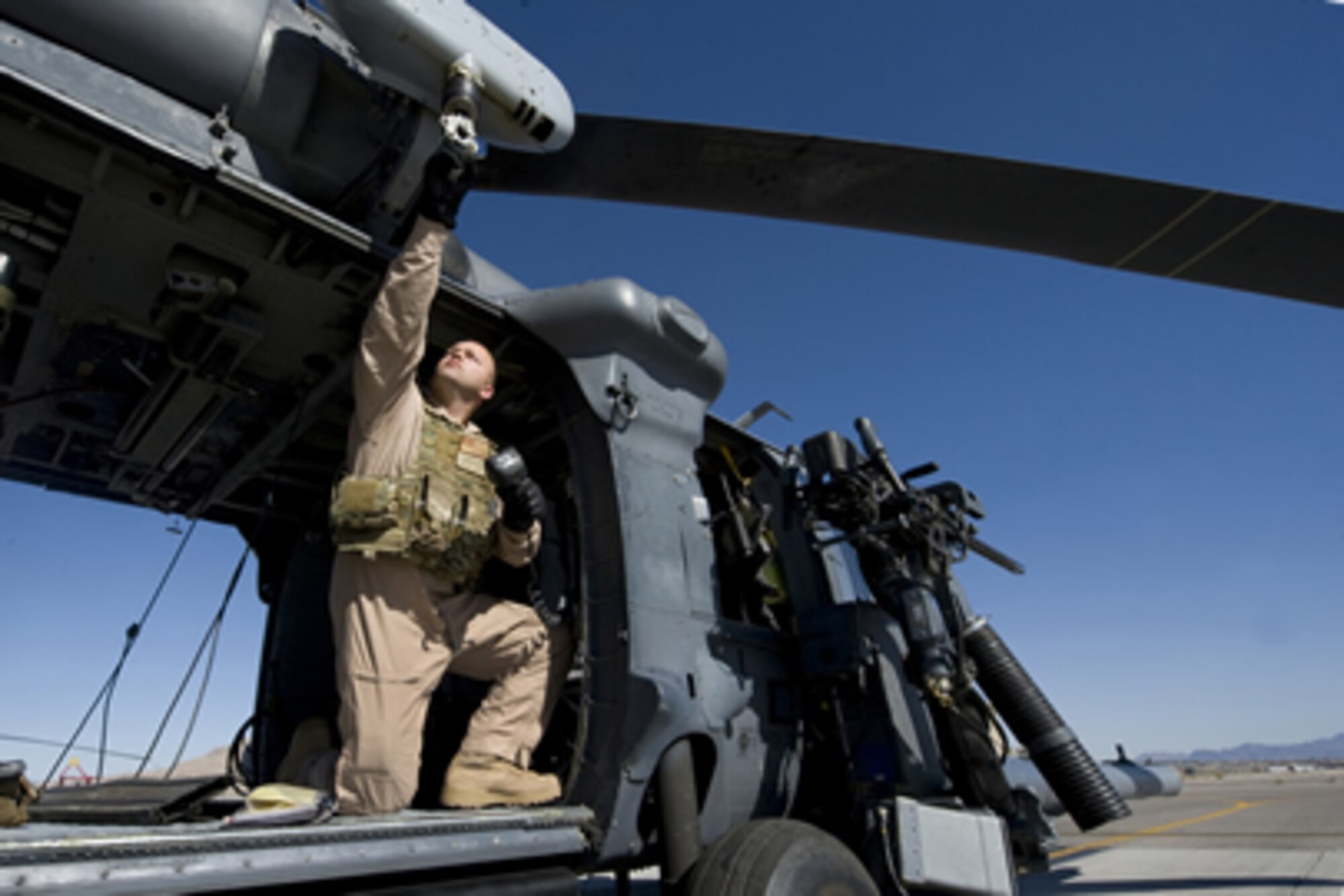 Staff Sgt. David Mullikin grabs the hoist of an HH-60 Pavehawk at Nellis Air
Force Base, Nev., June 23, 2011. Sergeant Mullikin is a flight engineer
assigned to the 66th Rescue Squadron.  He returned from a tour in Iraq
suffering from post-traumatic stress disorder and got help through the Air
Force Wounded Warrior program.  (U.S Air Force photo/Senior Airman Stephanie
Rubi)
