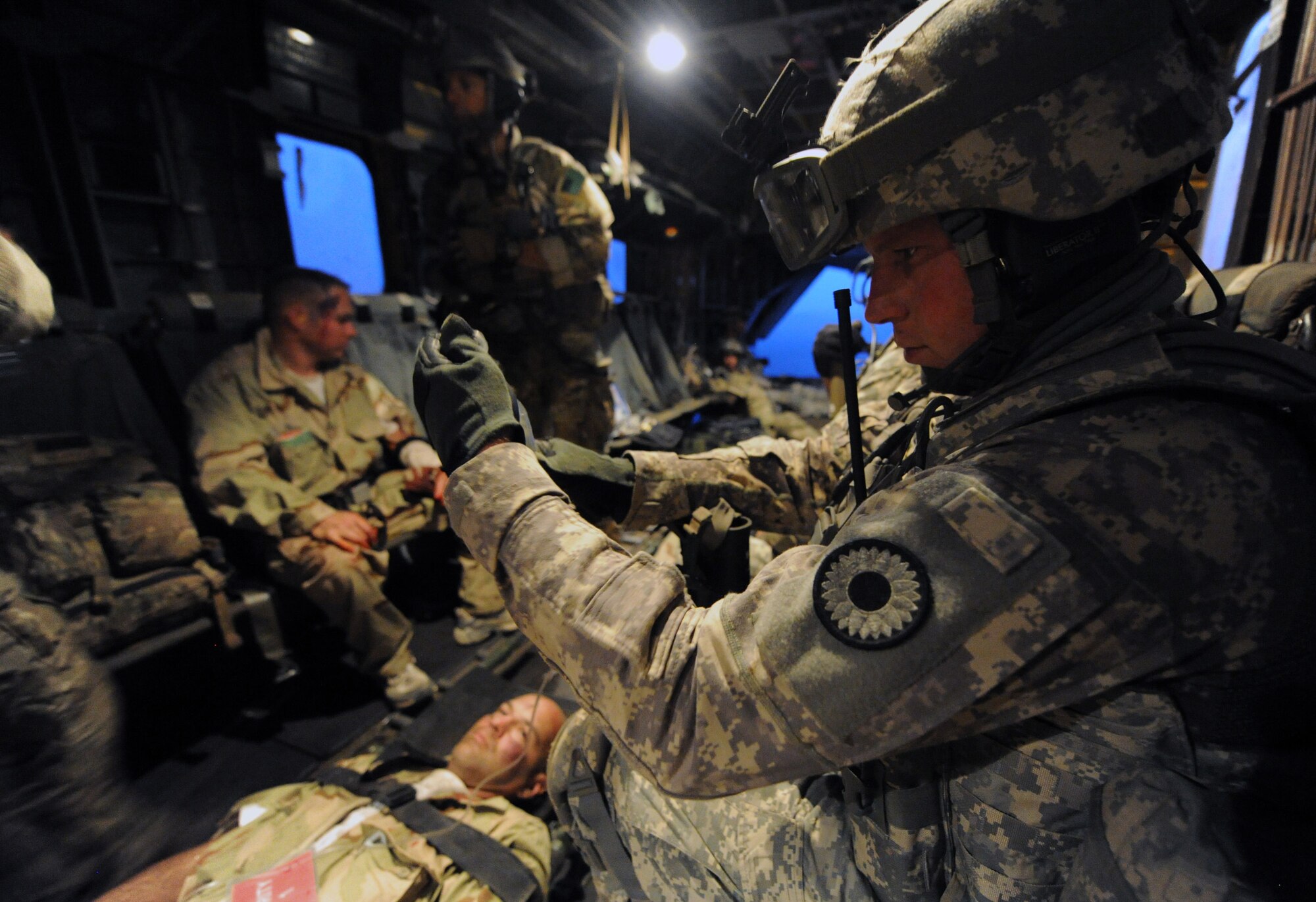 DJIBOUTI, Africa -- U.S. Army Sergeant Michael Stine, 1st Battalion 161st Field Artillery, holds an IV bag for a victim of a simulated aircraft crash during a personnel recovery exercise June 16.  U.S. Air Force pararescuemen and U.S. Army soldiers extracted six mock casualties from the Grand Bara desert, performing lifesaving medical procedures aboard Marine Corps MH-53 helicopters transporting them to back Camp Lemonnier.  The scenario was part of a joint training exercise involving all branches of the U.S. military stationed at Camp Lemonnier, Djibouti. (U.S. Air Force photo by Staff Sgt. Austin M. May)