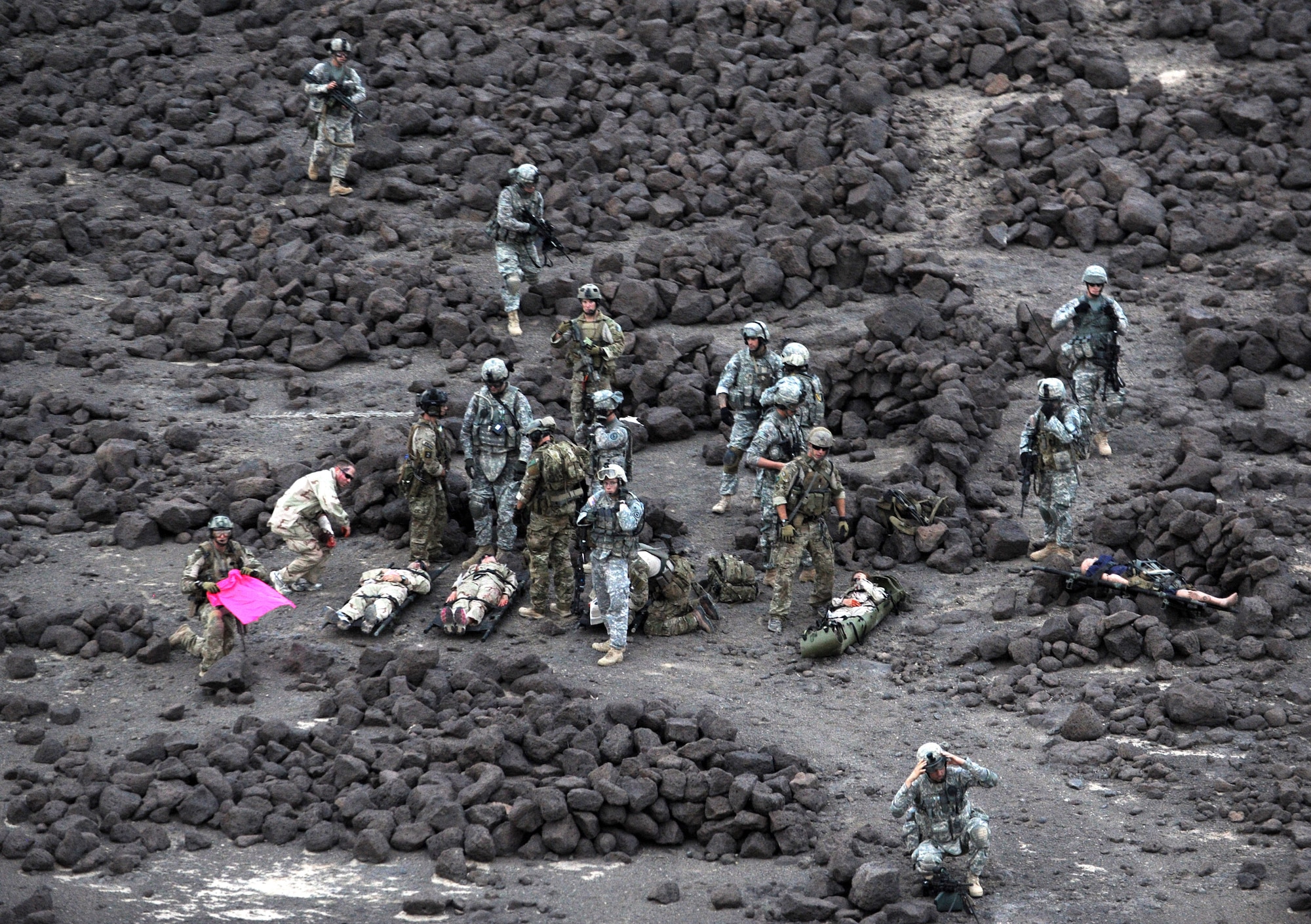 DJIBOUTI, Africa -- A group of U.S. Air Force pararescuemen, U.S. Army site security team members and victims of a simulated aircraft crash await the arrival of a U.S. Marine Corps MH-53 helicopter in the Grand Bara desert, Djibouti, June 16.  The scenario was part of a joint training exercise involving all branches of the U.S. military stationed at Camp Lemonnier, Djibouti. (U.S. Air Force photo by Staff Sgt. Austin M. May)