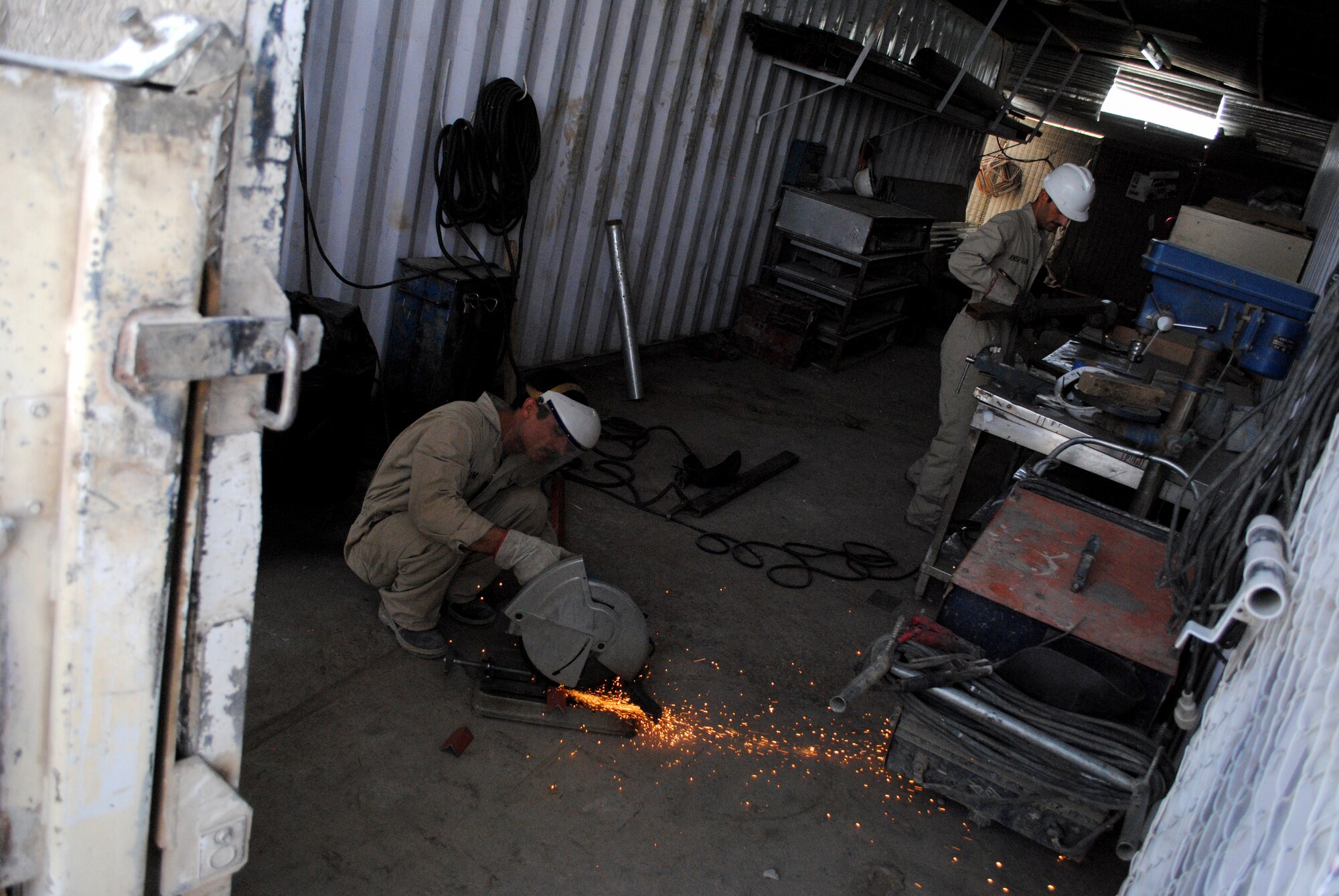 Abdul Qadar, a welder, cuts pieces of metal in a workshop at Camp Hero, on Jun. 25, 2011, in Kandahar, Kandahar province, Afghanistan.  Qadar is one of many civilian workers trained in an Afghan Ministry of Defense program to maintain buildings on Afghan military bases.  (U.S. Air Force photo by Tech Sgt. Adrienne Brammer)
