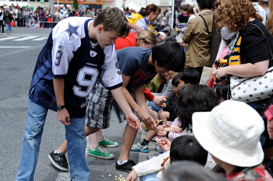 MISAWA AIR BASE, Japan -- Members of the Misawa Air Base community hand candy to children during the 23rd Annual American Day parade June 26, 2011 in Misawa City. American Day is an annual event hosted by the 35th Fighter Wing and the Misawa International Club. (U.S. Air Force photo/Staff Sgt. Marie Brown/Released)