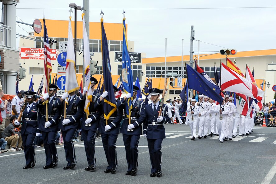 MISAWA AIR BASE, Japan -- The Misawa Air Base Honor Guard carry the colors, followed by sailors carrying 50 state flags during the 23rd Annual American Day parade June 26, 2011 in Misawa City. American Day is an annual event hosted by the 35th Fighter Wing and the Misawa International Club.  (U.S. Air Force photo/Staff Sgt. Marie Brown/Released)