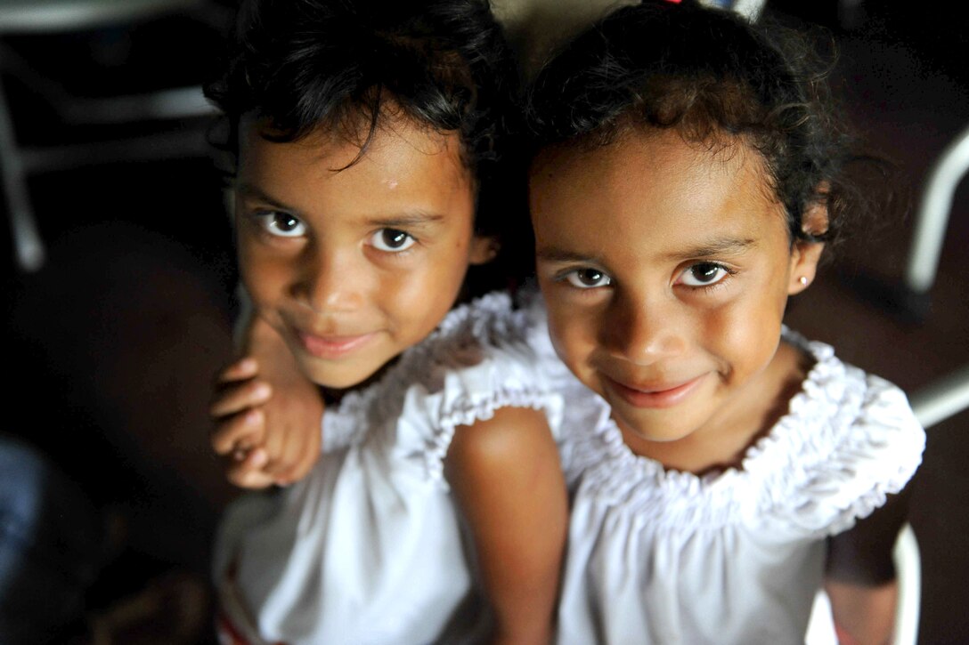Twin Nicaraguan girls pose for a photograph during a medical consultation at the Escuela Humberto Mendez Juarez medical site during a Continuing Promise 2011 medical community service event in San Jaun Del Sur, Nicaragua, June 20, 2011.