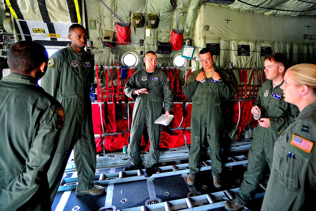 Air Force Maj. Jonathan Watson, center left, briefs airmen aboard a C-130 Hercules aircraft before an airdrop mission during a joint operations access exercise on Fort Bragg, N.C., June 22, 2011. Watson is a pilot assigned to the 2nd Airlift Squadron. The  two-week exercise prepares airmen and soldiers to respond to worldwide crises and contingencies.