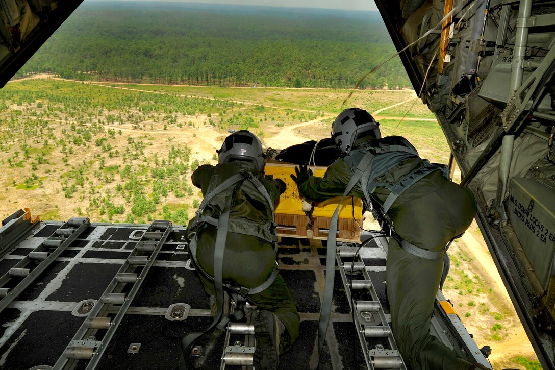 Air Force Senior Airman Terrance Greene and Staff Sgt. Samuel Gilbert force a package off the ramp of a C-130 Hercules’ cargo bay during a joint operations access exercise on Fort Bragg, N.C., June 22, 2011. Greene and Gilbert are loadmasters assigned to the 2nd Airlift Squadron.