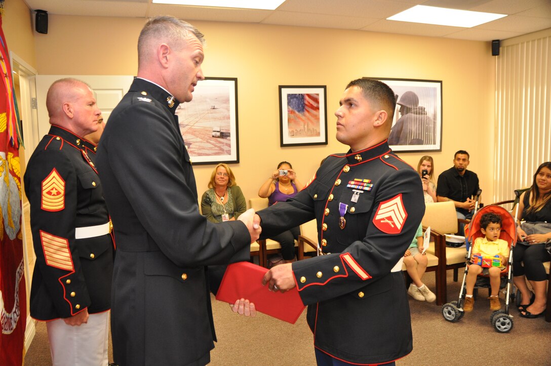 Former Marine Sgt. Adolfo M. Bayardo (right) is presented with the Purple Heart by Col. Daniel P. Ermer, commanding officer MCLB Barstow, Calif. Bayardo was shot in the neck in 2003 during a firefight in Iraq, but the bullet was not detected until 2009 during an X-Ray at Lloma Linda Unversity Medical Center Veterans Hospital, Loma Linda, Calif. The bullet is still in Bayardo's neck and is considered in operable.