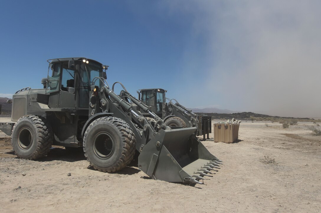 Construction vehicles with Engineering Co., Marine Wing Support Squadron 374, waits to be loaded on to transportation vehicles for the trip back to main side at Lavic Lake after The MWSS-374 constructed new helicopter landing pads at the site June 28, 2011.::r::::n::