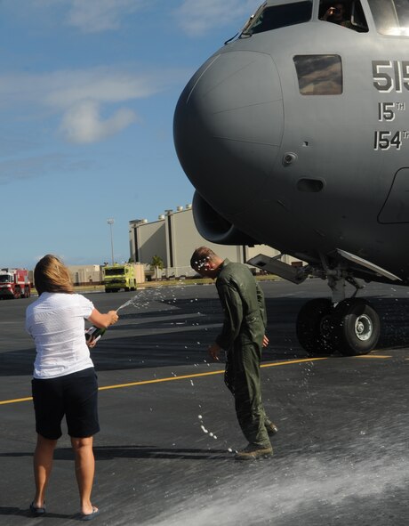 Col. Jeffrey Morgan, 15th Operations Group commander, gets sprayed with champagne by his wife following his final flight in a 535th Airlift Squadron C-17 Globemaster III June 23. Colonel Morgan and his family are making a permanent change of station to the Pentagon in Washington D.C. (U.S. Air Force photo/Senior Airman Lauren Main)