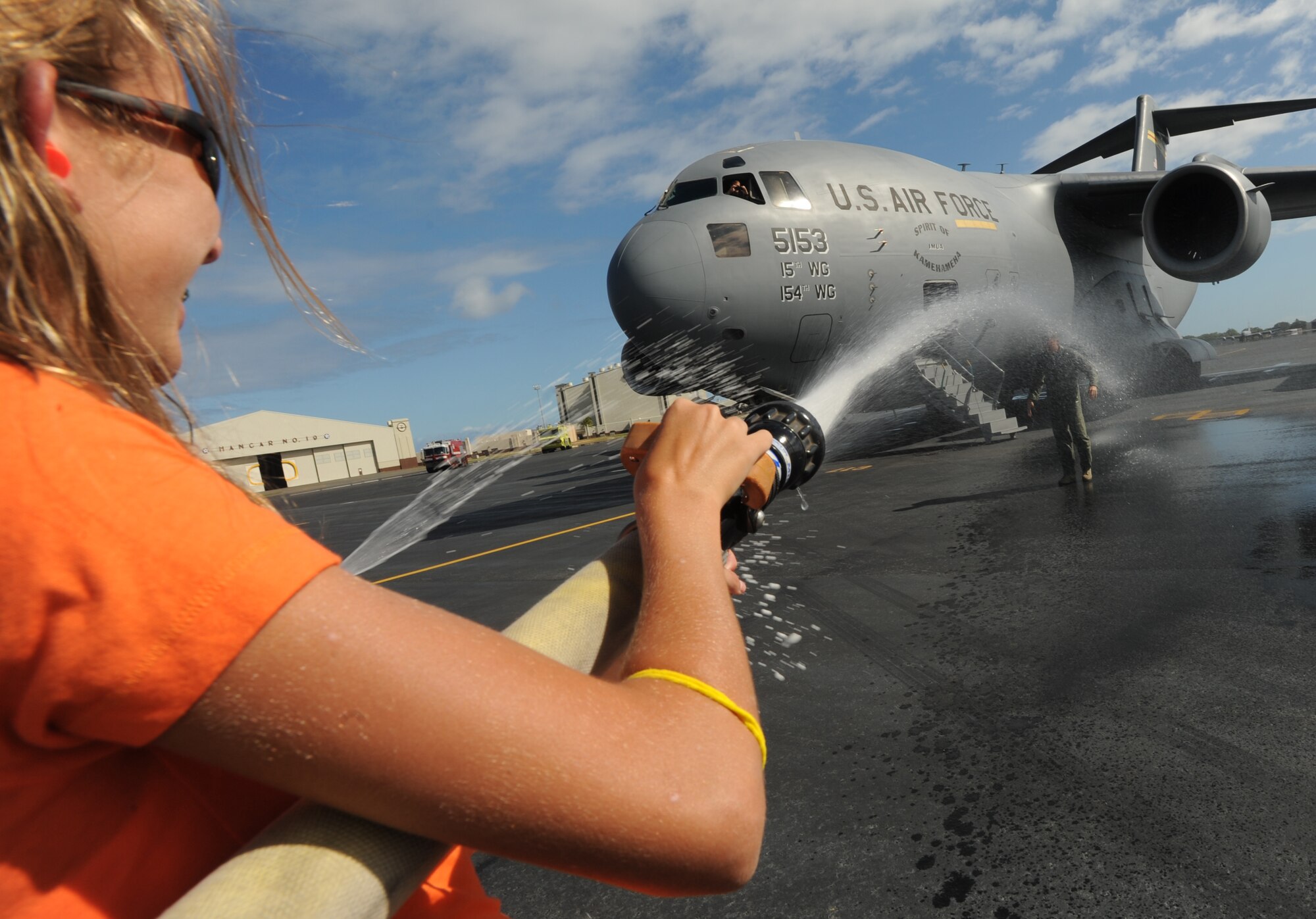 Col. Jeffrey Morgan, 15th Operations Group commander, gets hosed by his daughter after his final flight in a 535th Airlift Squadron C-17 Globemaster III June 23. Colonel Morgan and his family are making a permanent change of station to the Pentagon in Washington D.C. (U.S. Air Force photo/Senior Airman Lauren Main)