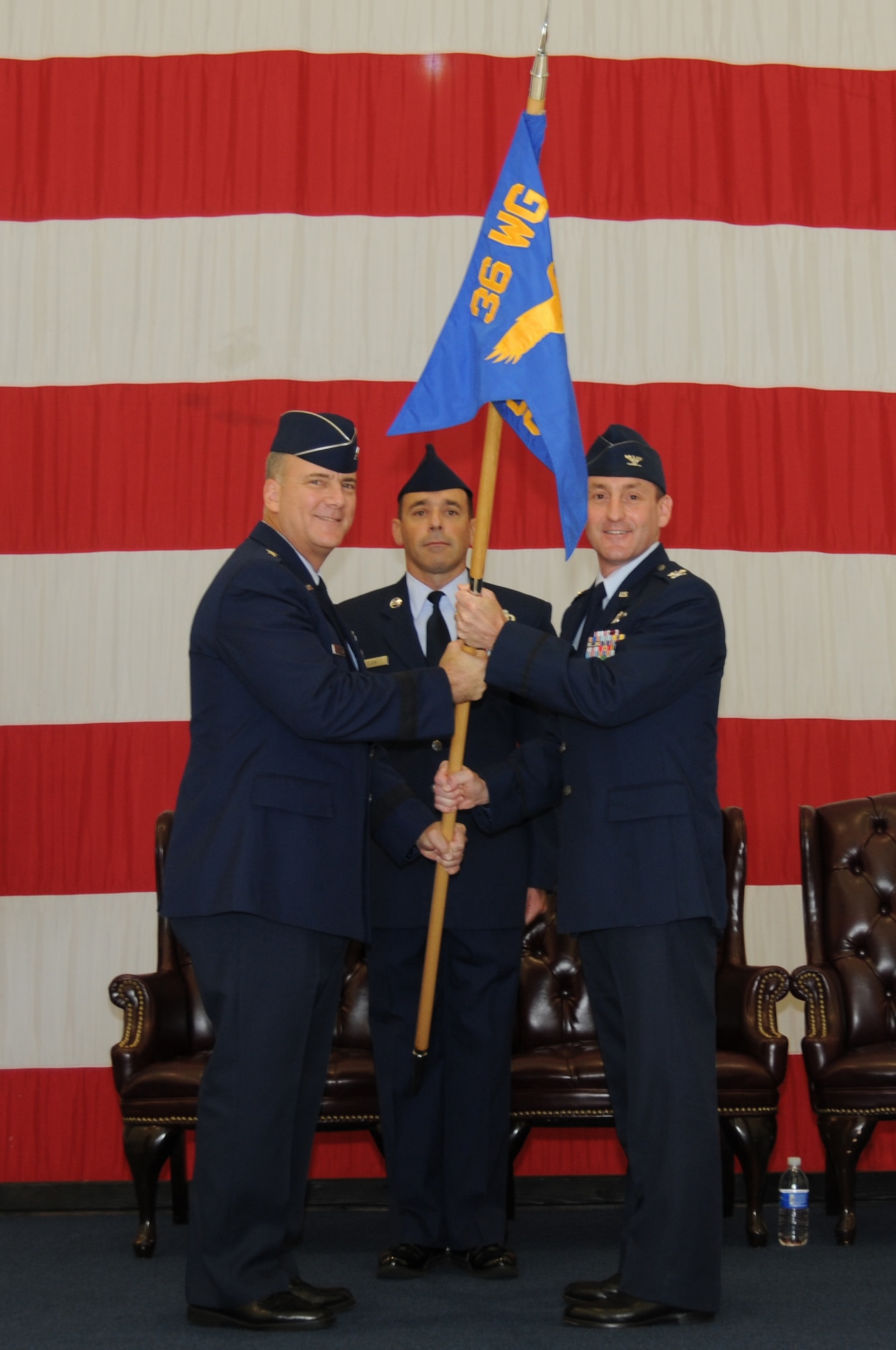 Brig. Gen. John Doucette (left), 36th Wing commander, passes the 36th Operations Group guidon to Col. Randy Kaufman, newly appointed 36 OG commander, during the change of command ceremony here June 28.(U.S. Air Force photo / Senior Airman Carlin Leslie)