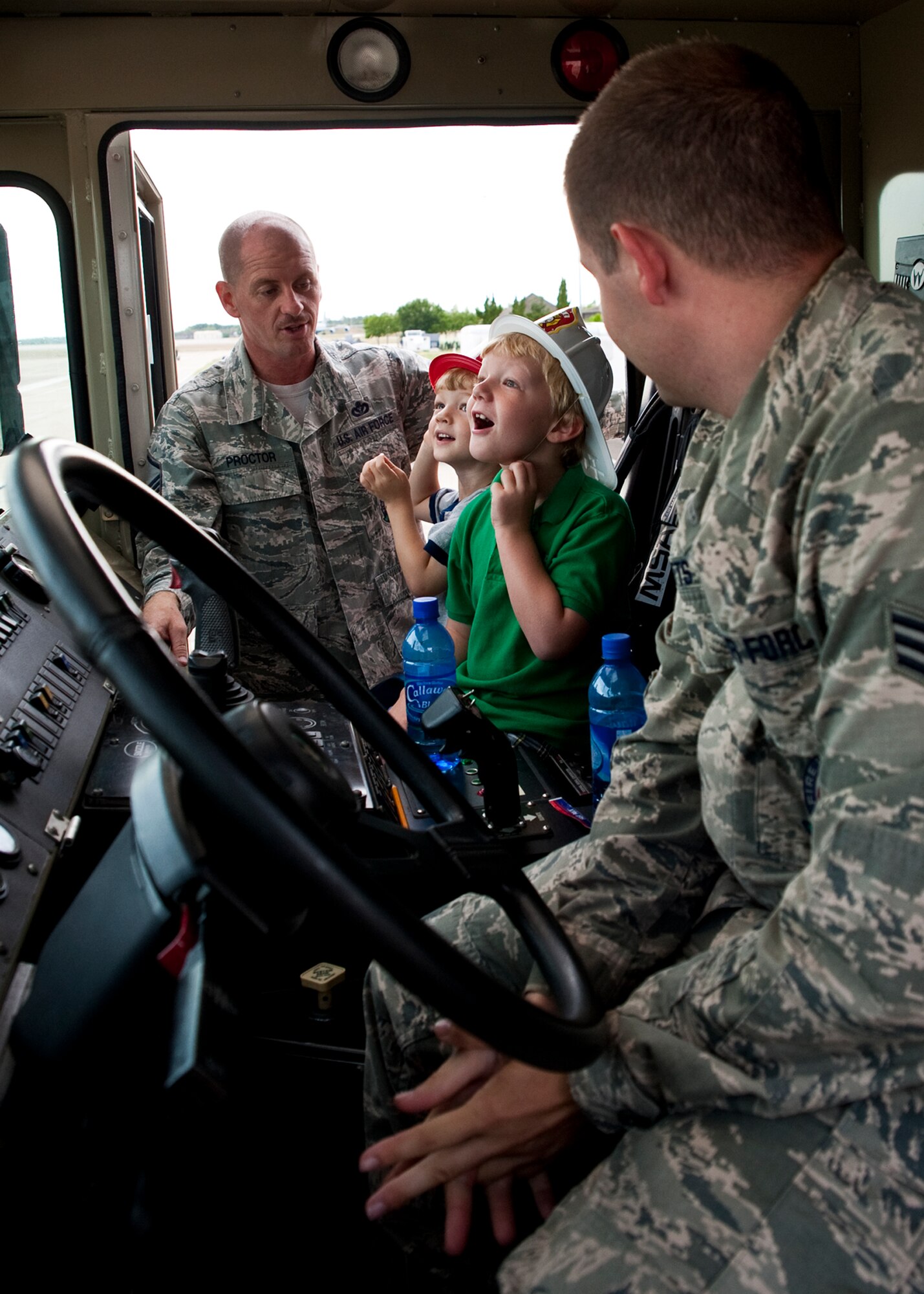 Six-year-old Andy Hitt and his 3-year-old brother Alex, sons of Senior Master Sgt. Kevin Hitt, Air Armament Center, marvel at the inside of a fire engine June 24 at Eglin Air Force Base, Fla.    Andy was recognized by the base fire department for saving his brother Alex from drowning in March.  As part of his recognition, he was made an honorary firefighter, sat in a fire engine and fired the water cannon.  (U.S. Air Force photo/Samuel King Jr.)