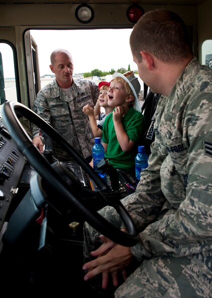 Six-year-old Andy Hitt and his 3-year-old brother Alex, sons of Senior Master Sgt. Kevin Hitt, Air Armament Center, marvel at the inside of a fire engine June 24 at Eglin Air Force Base, Fla.    Andy was recognized by the base fire department for saving his brother Alex from drowning in March.  As part of his recognition, he was made an honorary firefighter, sat in a fire engine and fired the water cannon.  (U.S. Air Force photo/Samuel King Jr.)