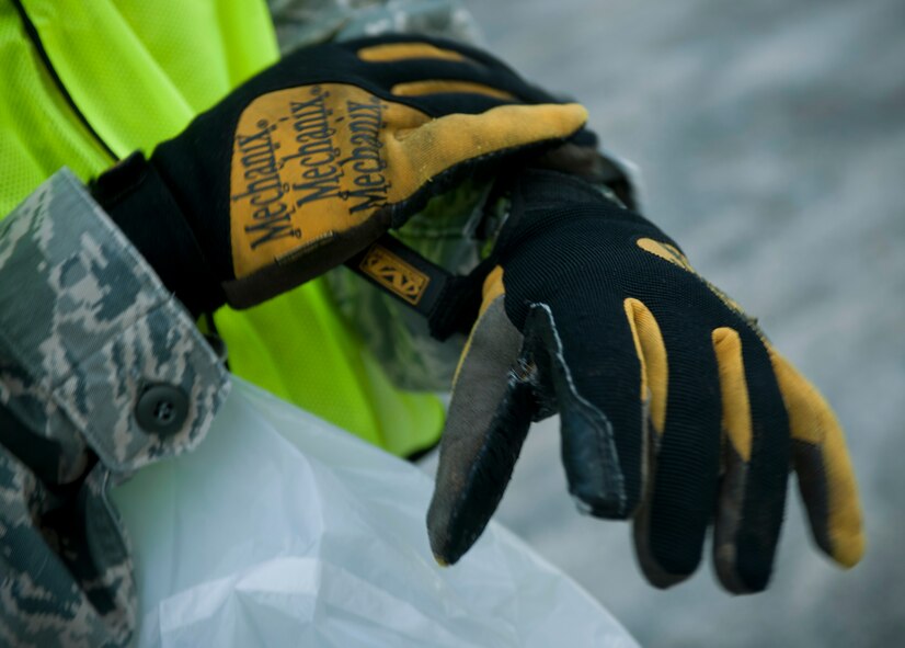 A member of the 23rd Wing staff dons his gloves before participating in a Pride Patrol at Moody Air Force Base, Ga., June 28, 2011. Each volunteer was required to wear gloves as a safety precaution as they picked up trash around the front of the base. (U.S. Air Force photo by Senior Airman Benjamin Wiseman/Released)