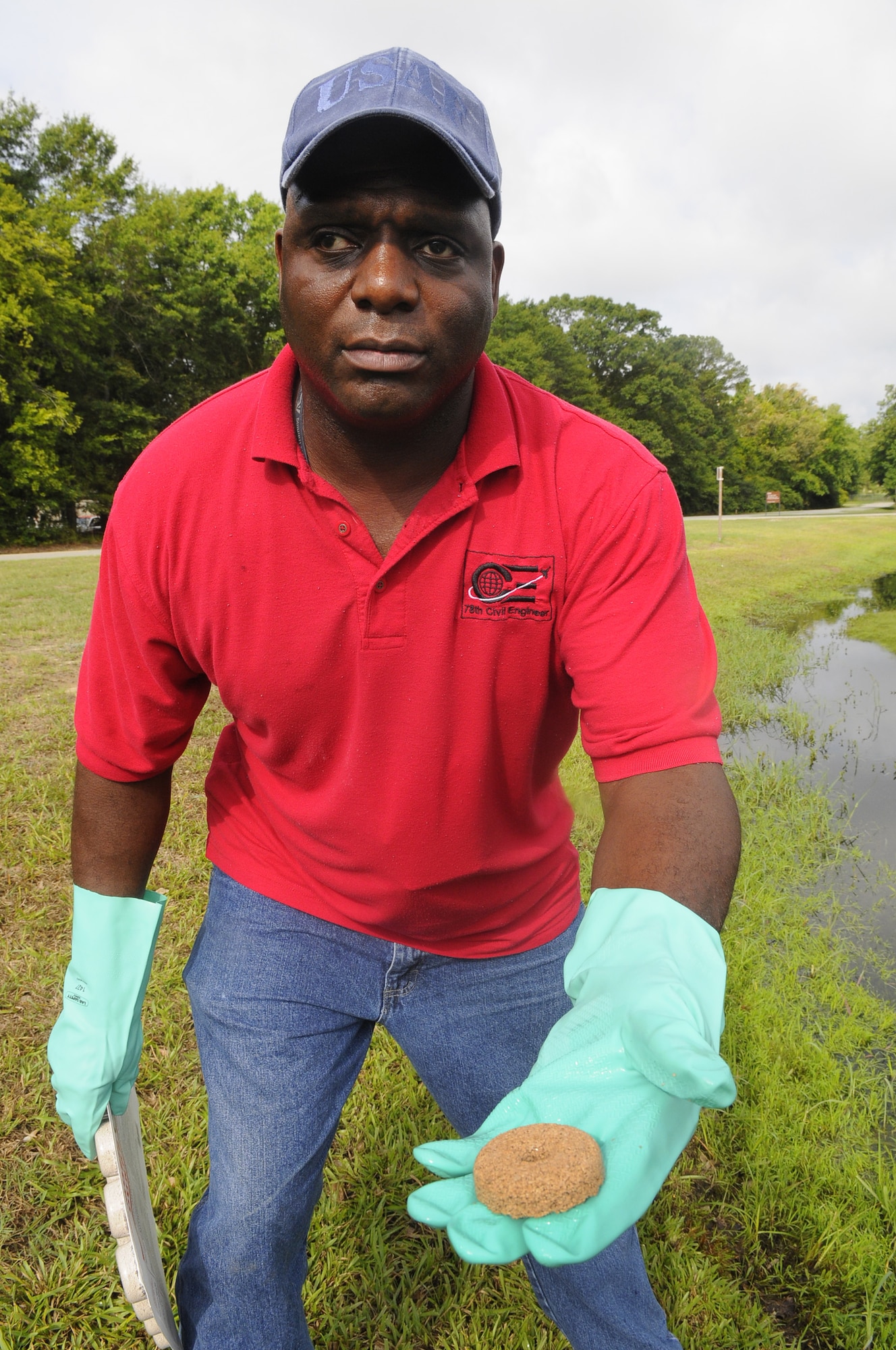 Mansur Cooper, pest control technician, holds a larvacide donut used in standing water. U. S. Air Force photo by Sue Sapp