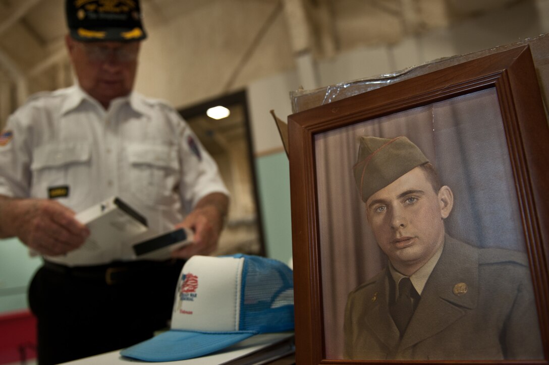 Marvin Knapp, Korean Veterans Association Chapter 160 commander, arranges his memorabilia in preparation for South Dakota Air and Space museum visitors who will be stopping to talk about his war experiences. War veterans from his group set up at the museum to commemorate the 61st anniversary of the start of the Korean War to better educate the public on the war and raise veteran awareness. (U.S. Air Force photo/Tech. Sgt. Nathan Gallahan/released)