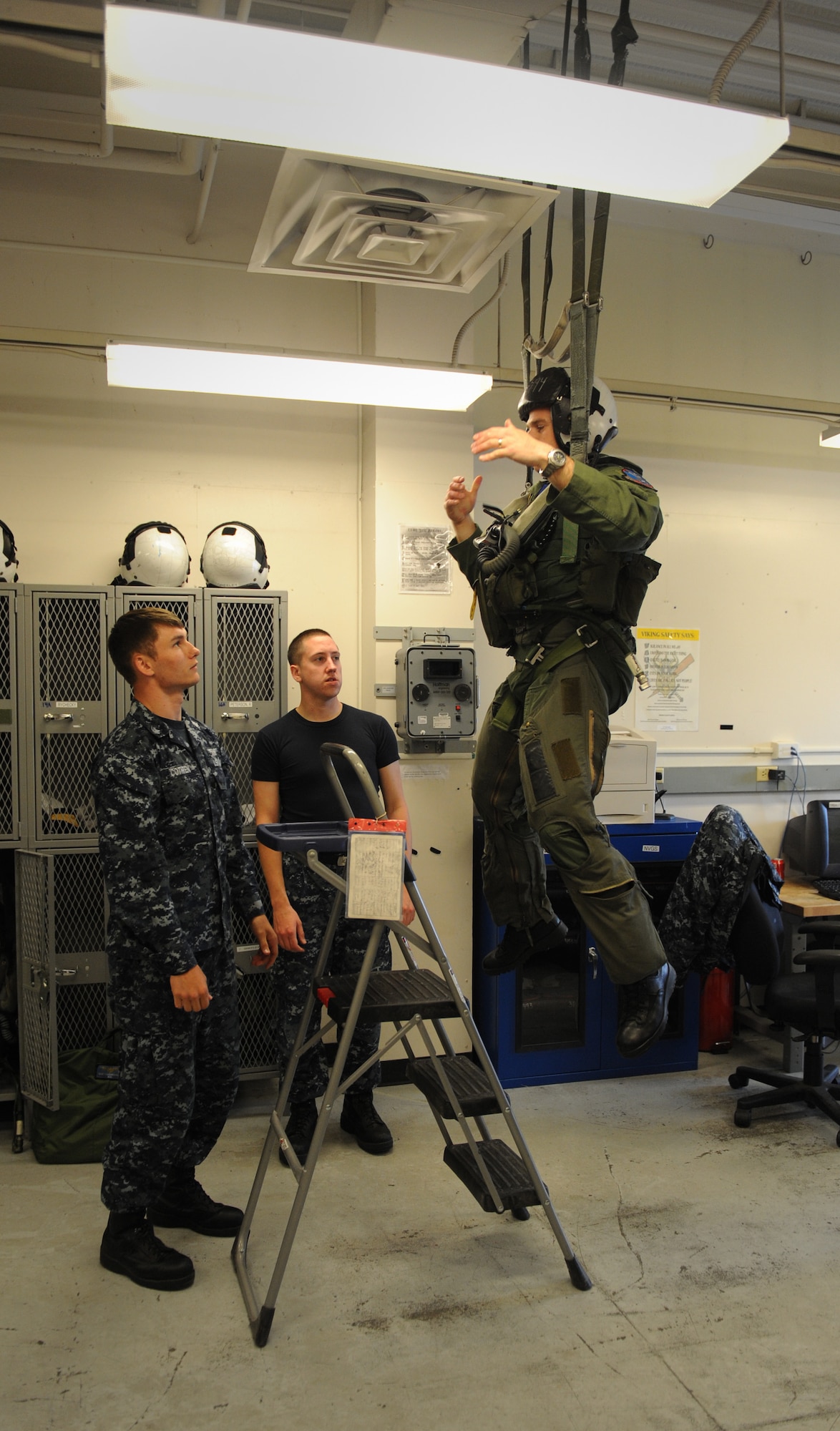 NAS WHIDBEY ISLAND, Wash. – Air Force Capt. Cole Davenport, Fixed Wing Electronic Attack Squadron 129 electronic warfare officer, hangs while aircrew survival equipmentmen perform a parachute harness safety check here June 9. Captain Davenport is part of the 390th Electronic Combat Squadron, which is attached to the 366th Fighter Wing, Mountain Home Air Force Base, Idaho. (U.S. Air Force photo by Staff Sgt. Gina Chiaverotti-Paige) 