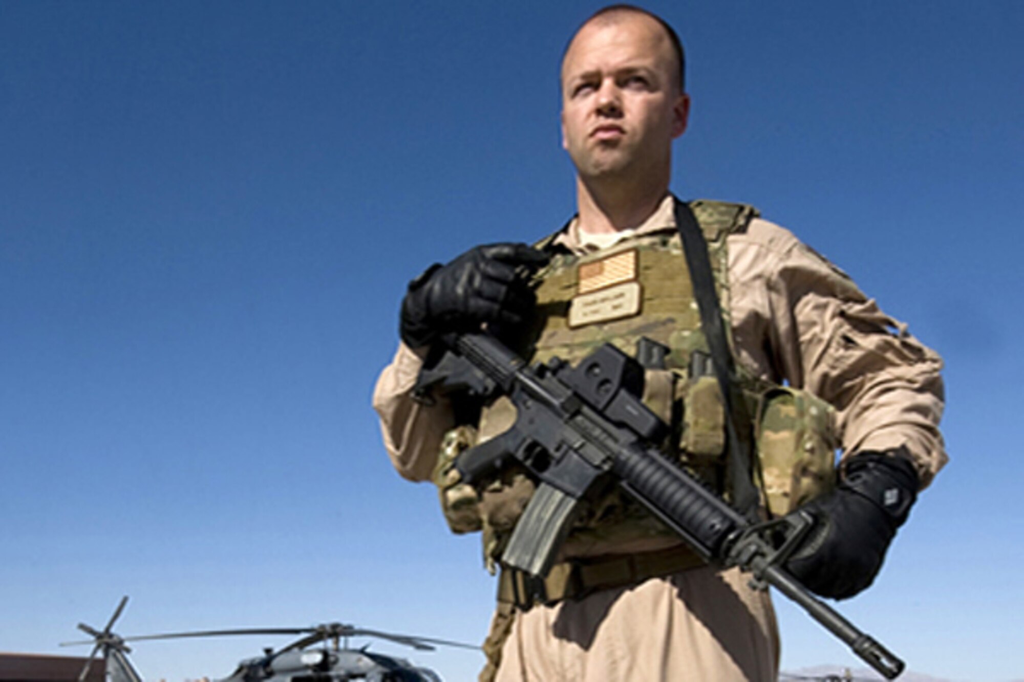 Staff Sgt. David Mullikin stands in front of an HH-60 Pave Hawk, in full operational gear June 23, 2011, at Nellis Air Force Base, Nev. Sergeant Mullikin is a flight engineer assigned to the 66th Rescue Squadron. He returned from a tour in Iraq suffering from post-traumatic stress disorder and got help through the Air Force Wounded Warrior program. (U.S Air Force photo/Senior Airman Stephanie Rubi) 