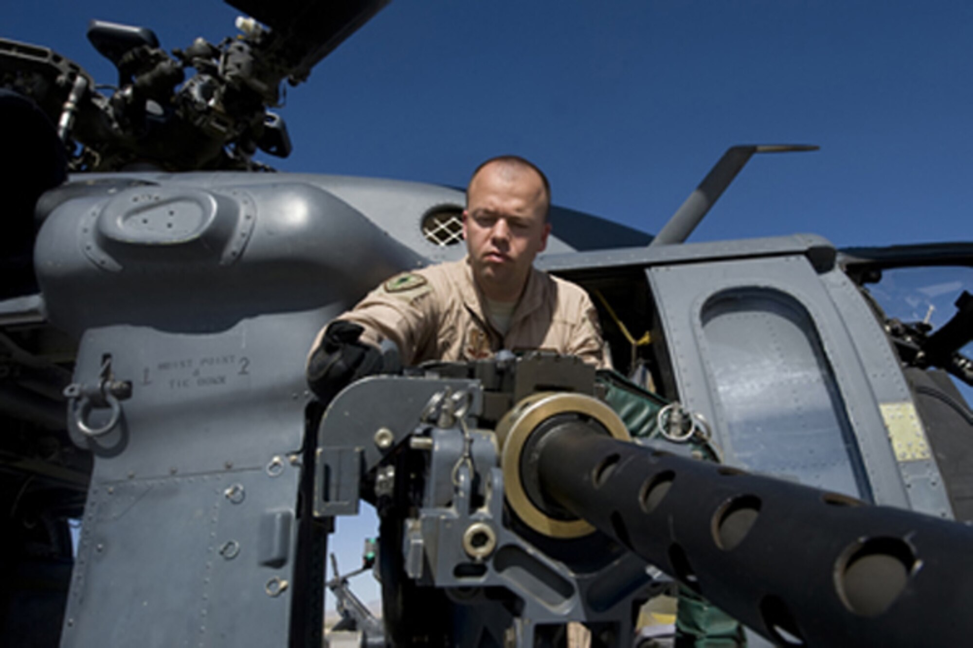Staff Sgt. David Mullikin conducts a pre-operations check on a 50-caliber machine gun attached to an HH-60 Pave Hawk June 23, 2011, at Nellis Air Force Base, Nev. Sergeant Mullikin is a flight engineer assigned to the 66th Rescue Squadron. He returned from a tour in Iraq suffering from post-traumatic stress disorder and got help through the Air Force Wounded Warrior program. (U.S Air Force photo/Senior Airman Stephanie Rubi) 