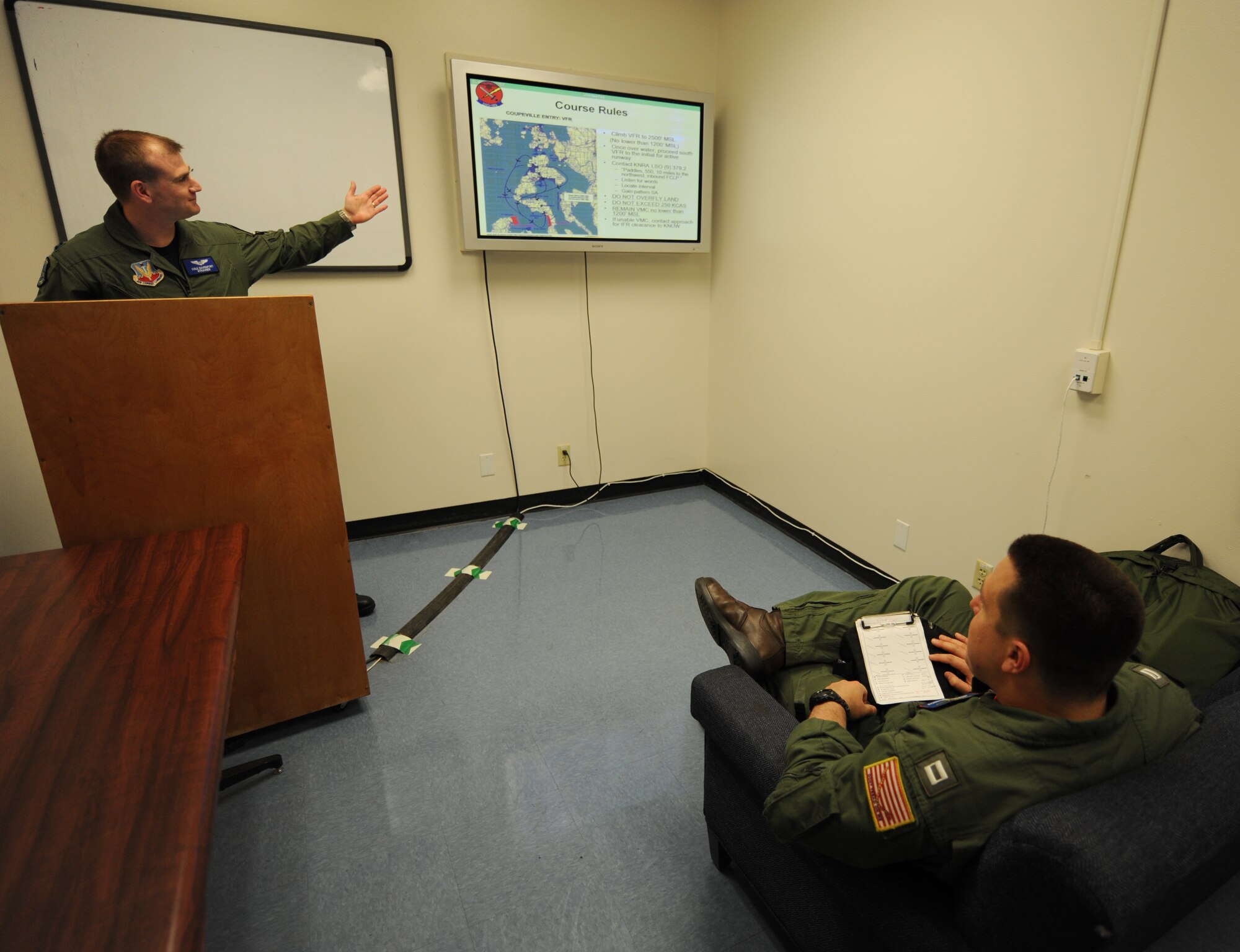 NAVAL AIR STATION WHIDBEY ISLAND, Wash. – Air Force Capt. Cole Davenport, Fixed Wing Electronic Attack Squadron 129 electronic warfare officer, provides a pre-flight brief to Navy Lieutenant Adamantius Kouloumoundras, a VAQ-129 EA-18G Growler pilot, here June 9. Captain Davenport is the first Air Force electronic warfare officer to graduate Growler training. (U.S. Air Force photo by Staff Sgt. Gina Chiaverotti-Paige)