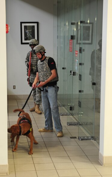 U.S. Air Force Staff Sgt. Joshua Hahn, 23rd Security Forces Squadron military working dog handler, and Dini search the Freedom I Fitness Center at Moody Air Force Base, Ga., for improvised explosive devices during an active shooter exercise June 24, 2011. Military installations are at a high risk of being attacked by an active shooter, so it’s important for everyone to be trained on how to identify the signs of one and how to react accordingly.  (U.S. Air Force photo by Senior Airman Stephanie Mancha/Released) 