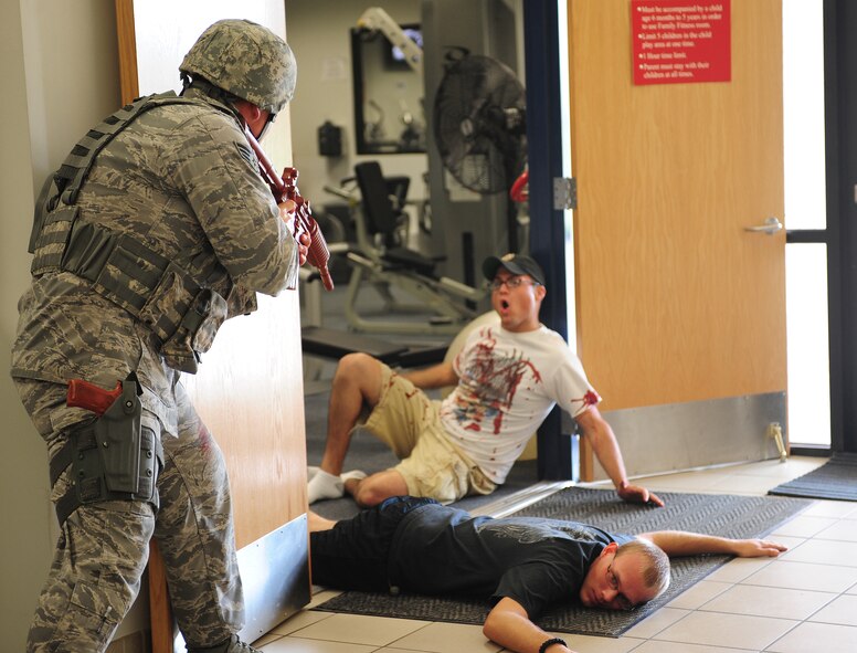 U.S. Air Force Senior Airman Chandler Kramer, 23rd Security Forces Squadron patrolman, orders a simulated victim to lie on the floor before entering a room during an active shooter exercise at Moody Air Force Base, Ga., June 24, 2011. Airman Kramer took necessary precautions to keep himself, his team and the victims safe while dealing with the gunman. (U.S. Air Force photo by Senior Airman Stephanie Mancha/Released)