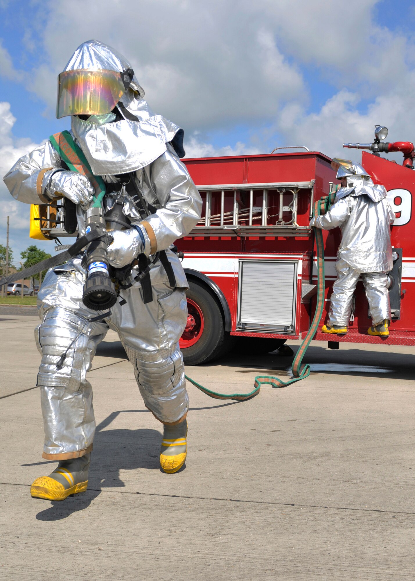 ROYAL AIR FORCE LAKENHEATH, England - (left to right) Airmen 1st Class Chris Hatch and Samuel Clanton, 48th Civil Engineer Squadron firefighters, work together with a fire hose during a training session outside the fire department,  June 24, 2011. The 48th CES firefighters train routinely to remain proficient in their response to emergencies. They also provide tours to British nationals, train for firefighter challenges, perform extrication demonstrations, provide fire prevention training and perform other duties. (U.S. Air Force photo/Senior Airman Tiffany M. Deuel)