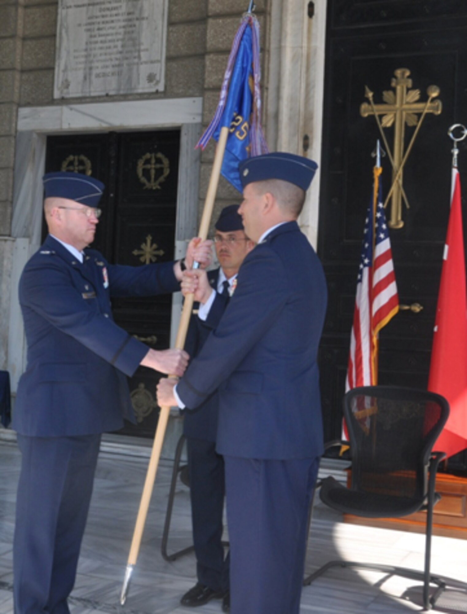 Lt. Col. Joel Elsbury, right, accepts the 425th Air Base Squadron guidon from  Col. Scott Enold, 39th Mission Support Group commander, during the 425th ABS change-of-command ceremony June 27, 2011, at the Izmir Chapel Garden, Çigli Air Base, Turkey. The 425th ABS is a geographically-separated unit of the 39th Air Base Wing that provides medical, legal, logistics, communications, security forces, morale, services, financial and engineering support to U.S. personnel assigned to Component Command Headquarters Air Izmir and tenant organizations. (Photo by Tanju Varlikli)
