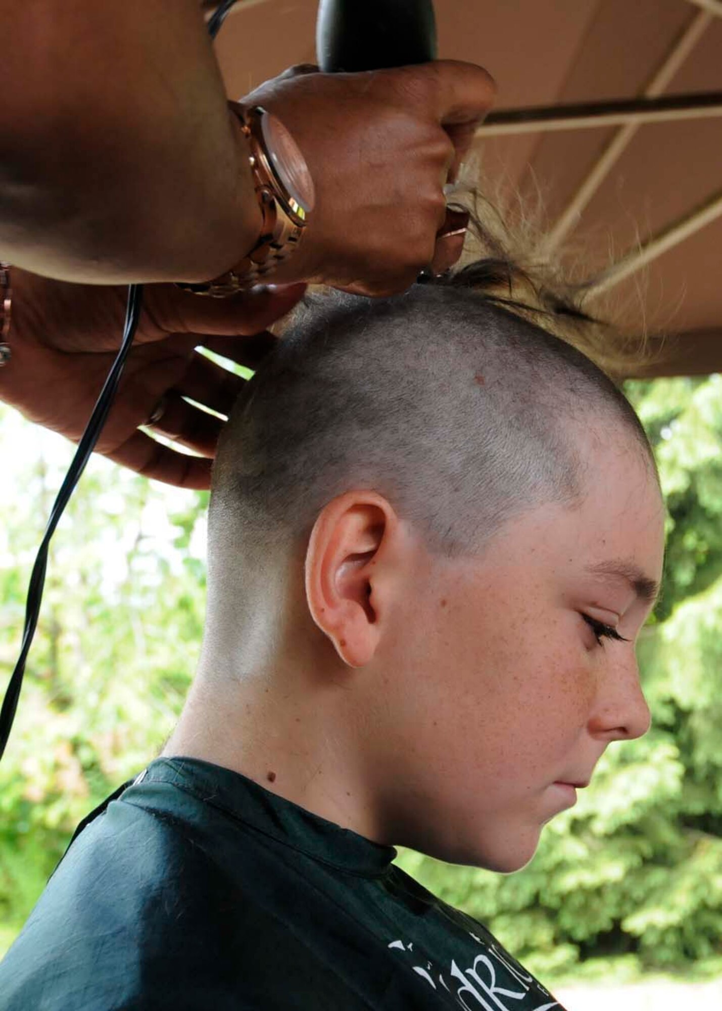 Logan Gurganus, 12, son of U.S. Air Force Senior Master Sgt.Don Gurganus, American Forces Network Ramstein superintendent, gets his head shaved in participation of the second annual St. Baldricks event on Ramstein Air Base, Germany, June 26, 2011. The St. Baldricks Foundation is an organization that tasks volunteers with getting sponsored to have their heads shaved as a demonstration of their camaraderie to children that have been diagnosed with cancer. (U.S. Air Force photo by Airman 1st Class Kendra Alba)