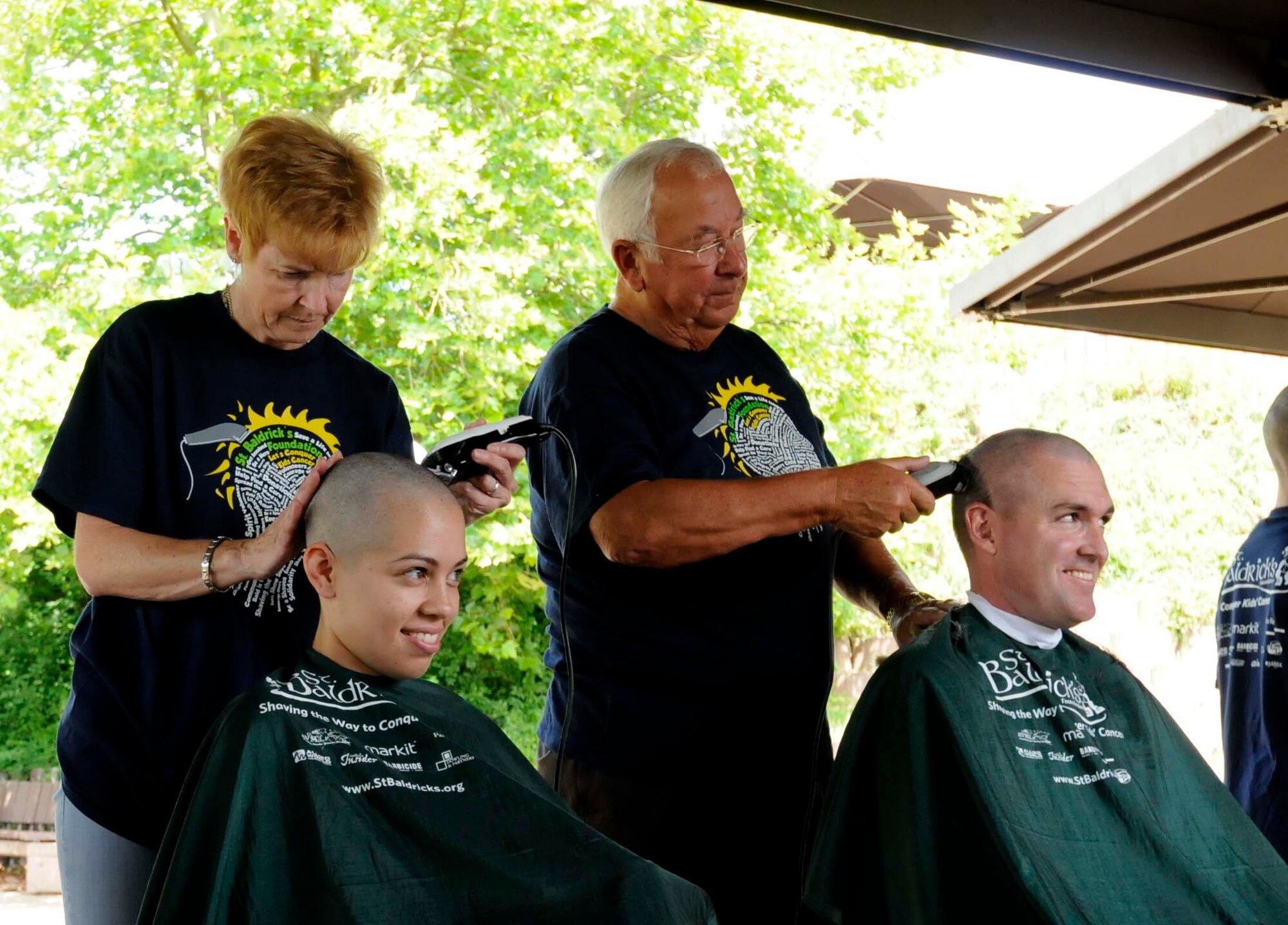 Tracy Alejandro, wife of U.S. Air Force Senior Airman Dexter Alejandro, 786 Force Support Squadron, and Senior Master Sgt. Don Gurganus, American Forces Network Ramstein superintendent, have their heads shaved in participation of the second annual St. Baldricks event on Ramstein Air Base, Germany, June 26, 2011. The St. Baldricks Foundation is an organization that tasks volunteers with getting sponsored to have their heads shaved as a demonstration of their camaraderie to children that have been diagnosed with cancer. (U.S. Air Force photo by Airman 1st Class Kendra Alba)