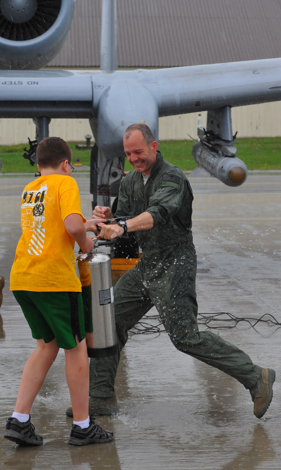 SPANGDAHLEM AIR BASE, Germany – Nate Fox, sprays water on his father, Col. Jackson Fox, 52nd Operations Group commander, after his final flight here June 24. Colonel Fox celebrated his last A-10 Thunderbolt II flight at Spangdahlem Air Base with family, friends and coworkers before taking command of the 39th Air Base Group at Incirlik Air Base, Turkey. (U.S. Air Force photo/Airman 1st Class Dillon Davis)