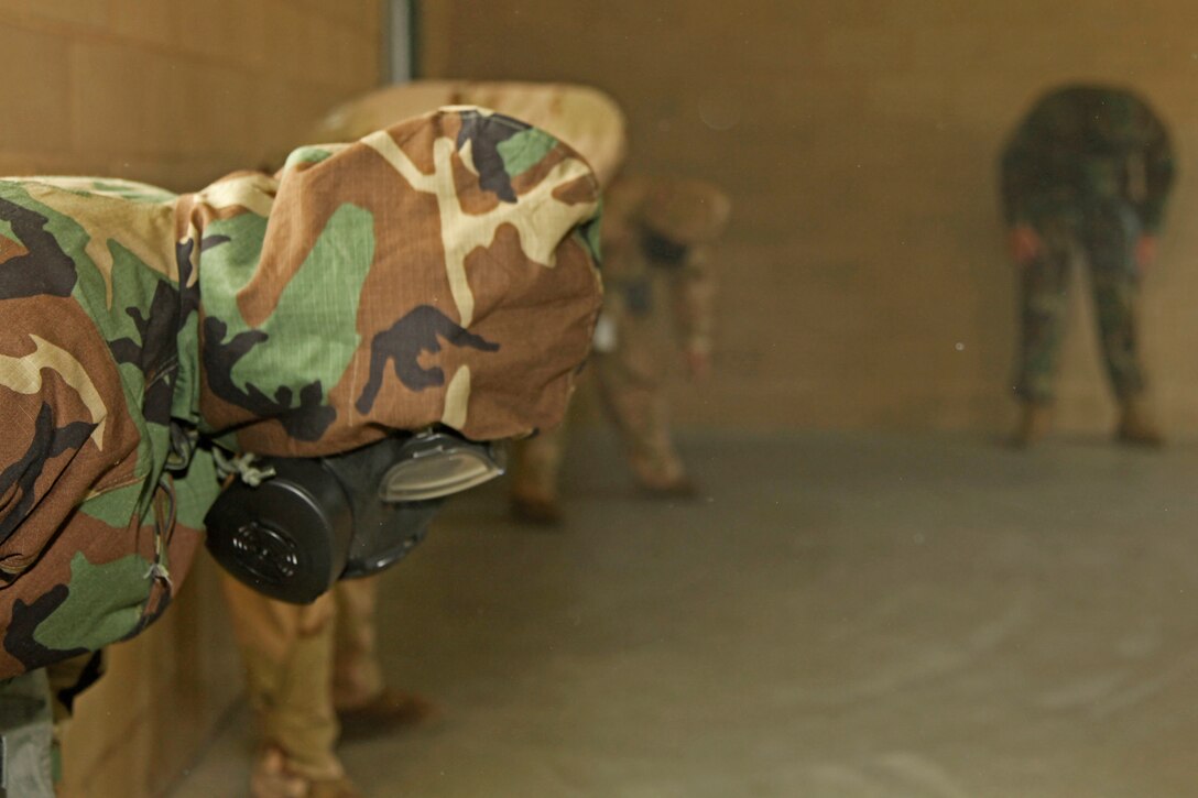 Marines and sailors with the 15th Marine Expeditionary Unit (MEU) shake their gas masks vigourously as a part of the Mask Confidence Exercise, an annual gas mask training, at the 33 Area Gas Chamber, June 28. The purpose of shaking the gas masks is to simulate intense physical movement and it ensures a tight seal to prevent contaminants in the environment from entering the mask. The 15th MEU is currently in its dwell period and uses this time to complete various annual training.